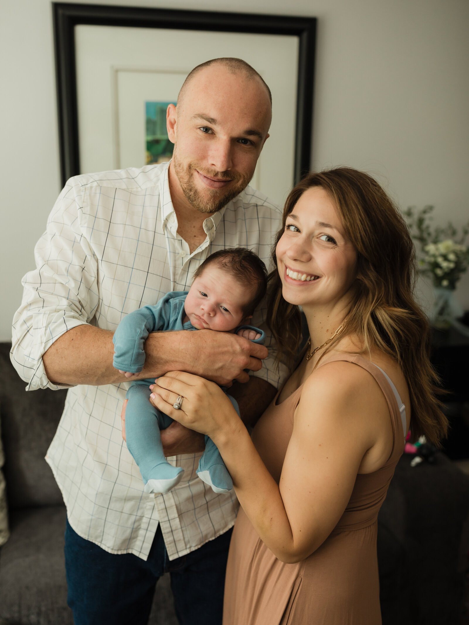 mom and dad holding newborn baby boy for in home lifestyle session cleveland newborn photographer