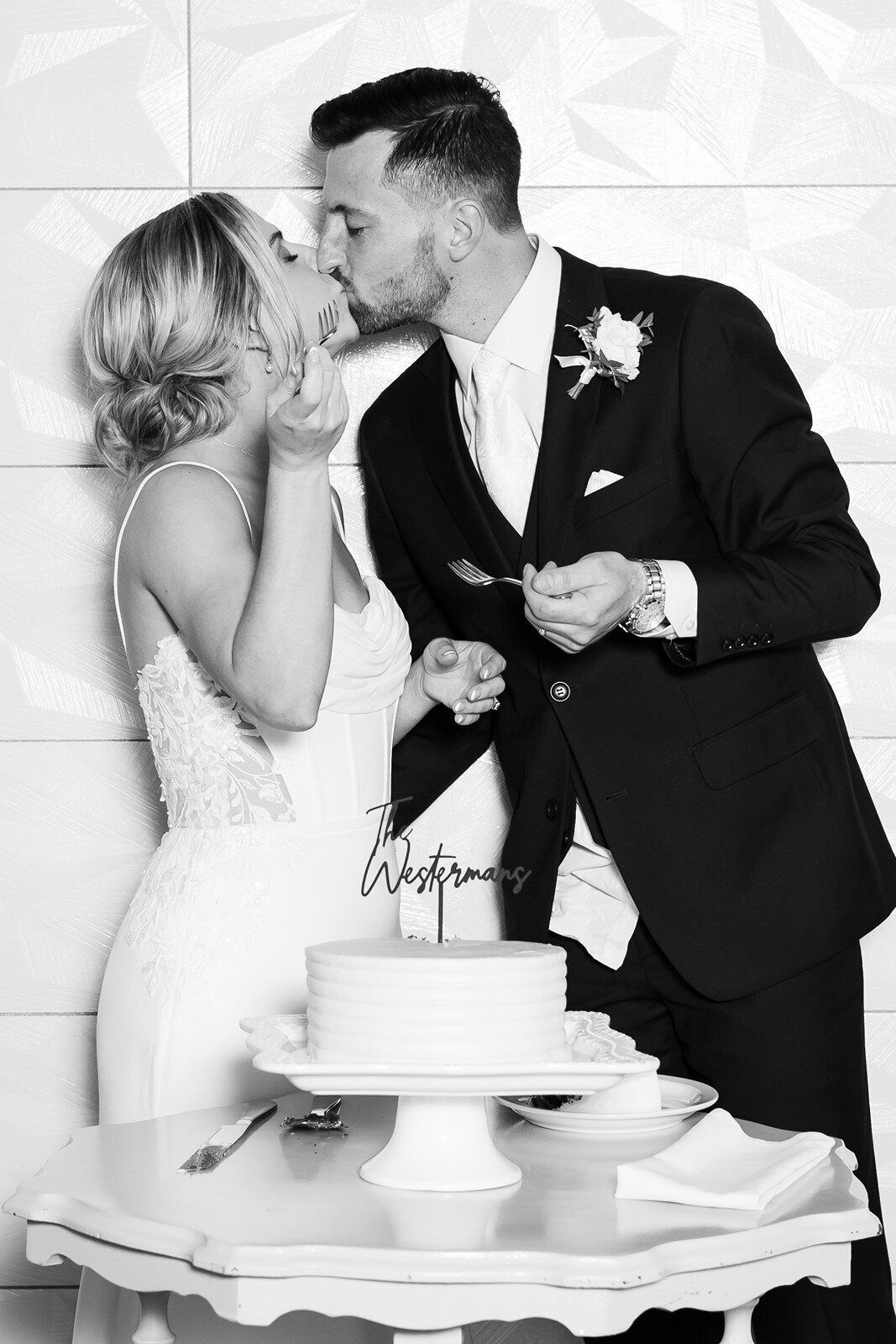 bride and groom kissing during their cake cutting ceremony
