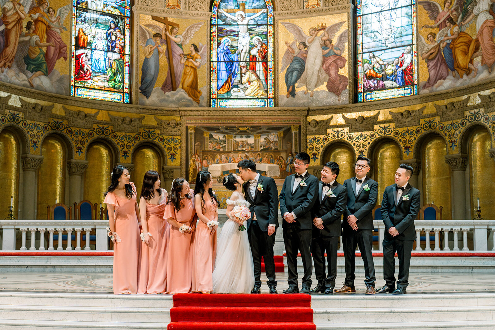 The bridal party stands together in front of the magnificent Stanford Memorial Church, showcasing their elegance and style.
