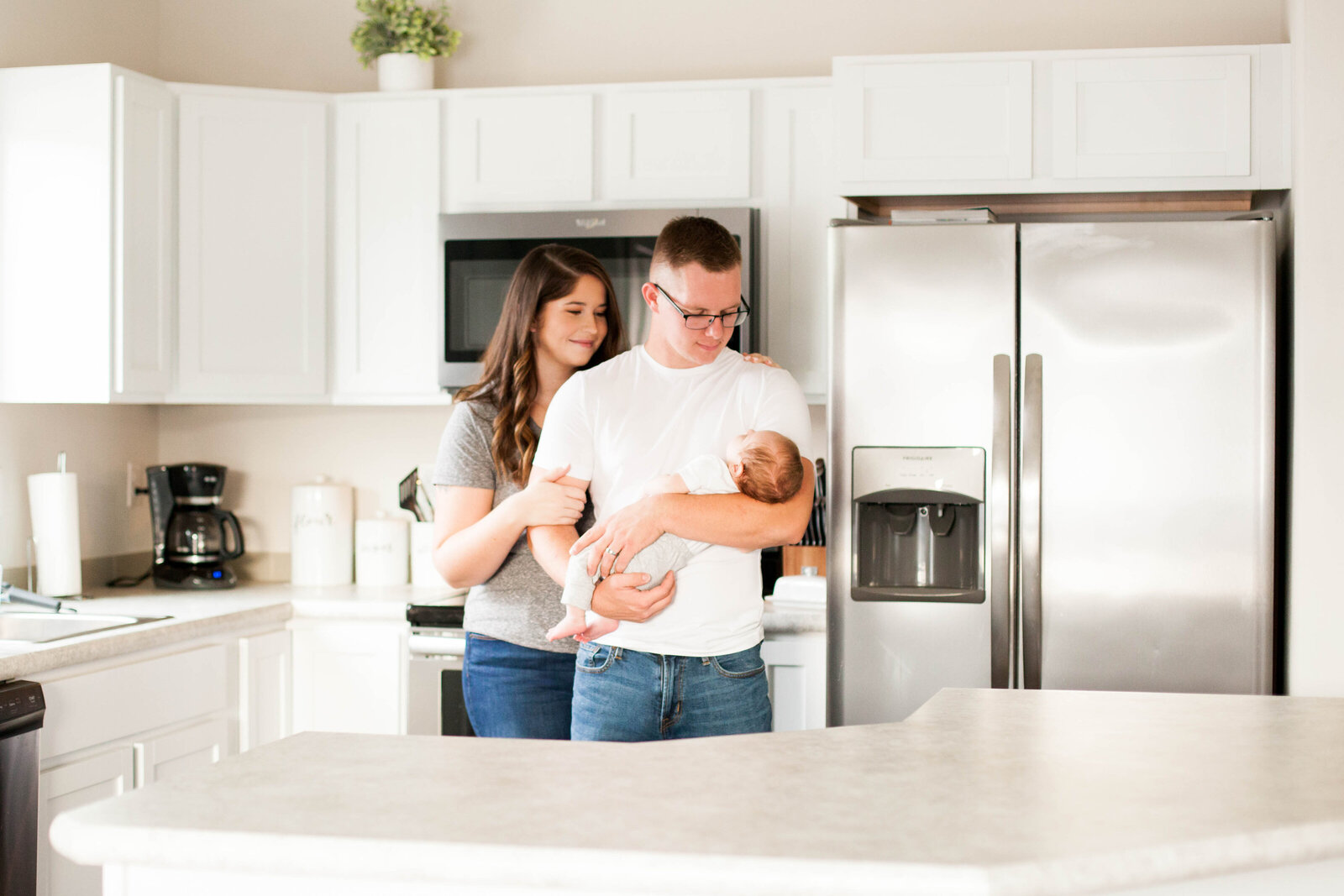 A lifestyle family photography session featuring a young family in their modern kitchen.