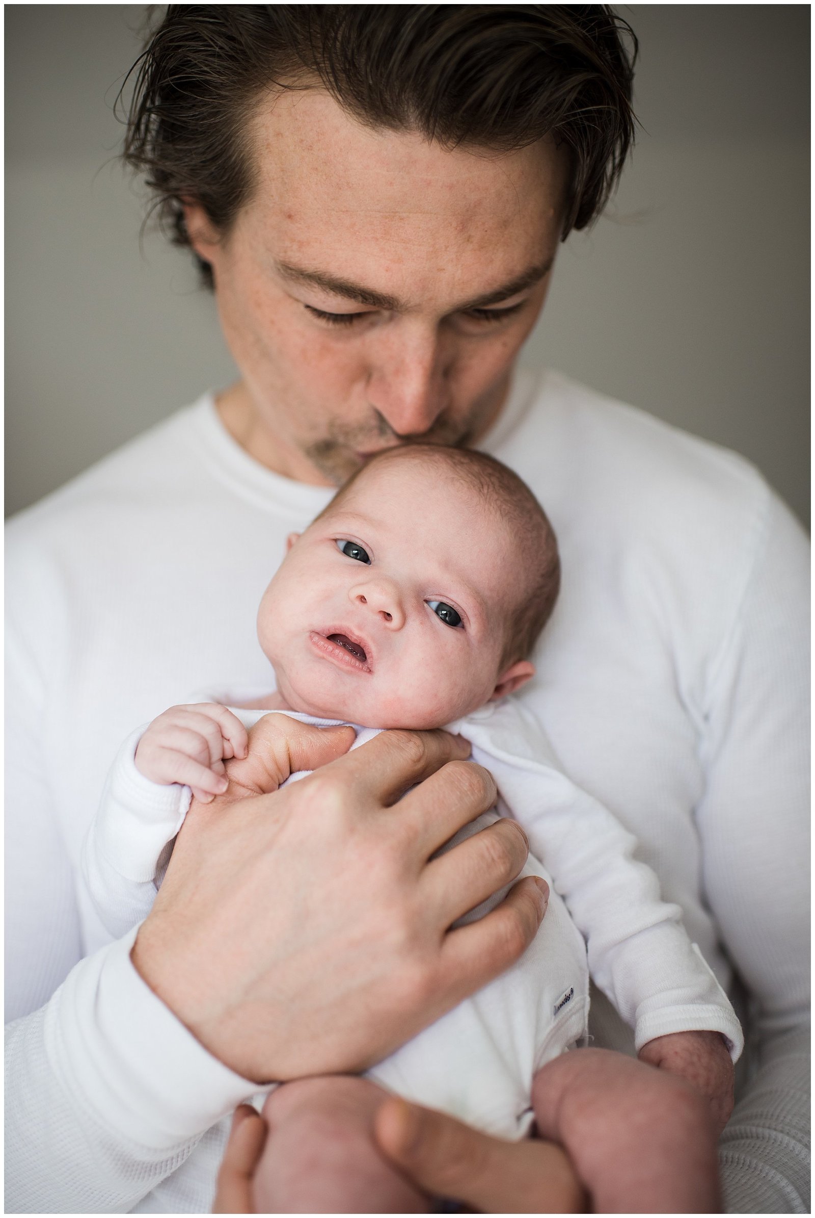 dad kising newborn baby girl in home lifestyle newborn photo session Emily Ann Photography Seattle Photographer