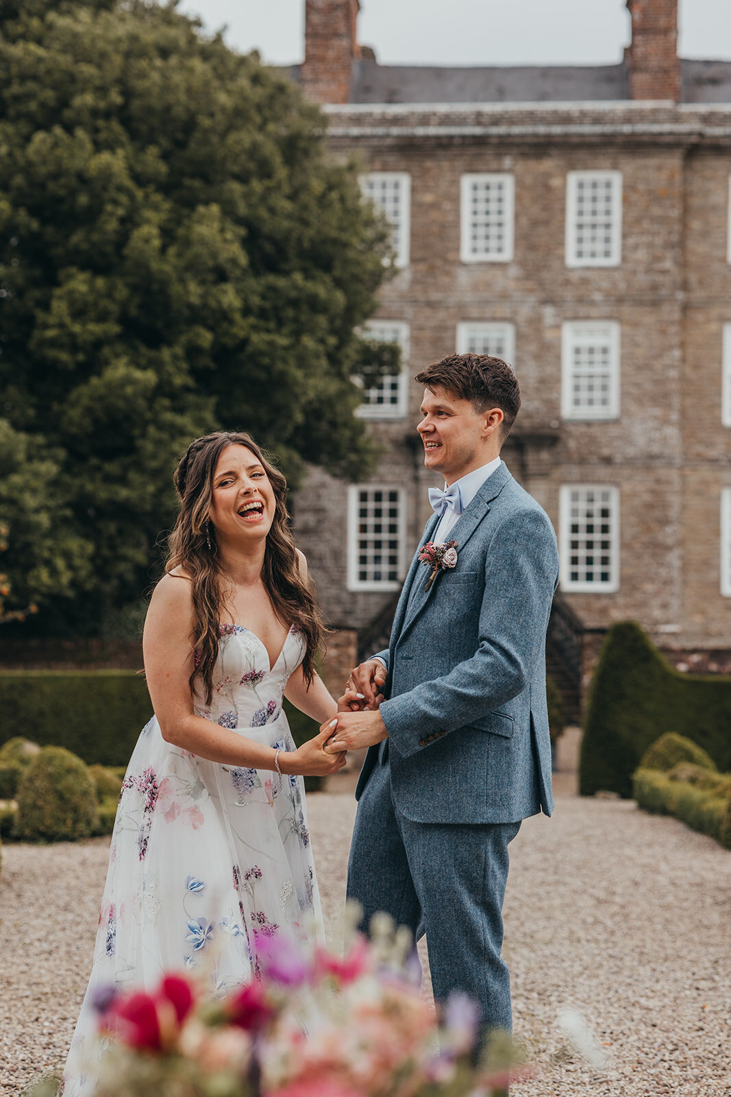 bride and groom hold hands and laugh