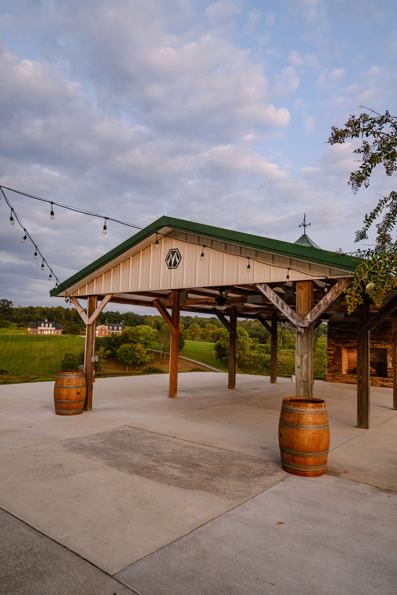 Outdoor event space with string lights and wooden pavilion overlooking the countryside at Willow and Stone Events in Mocksville, NC.