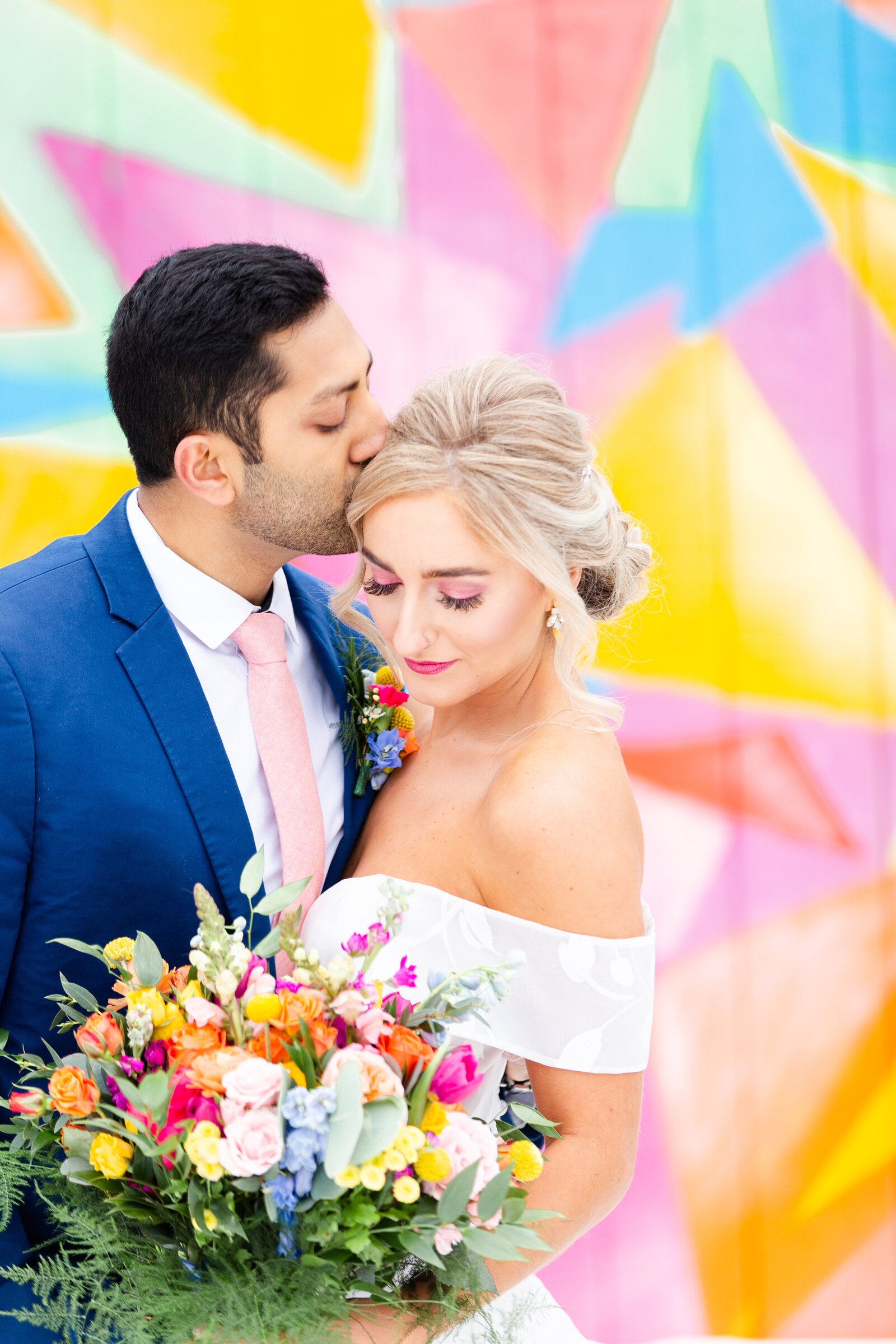 Bride and groom posing with colorful wall in Canton Ohio for DoubleTree Wedding