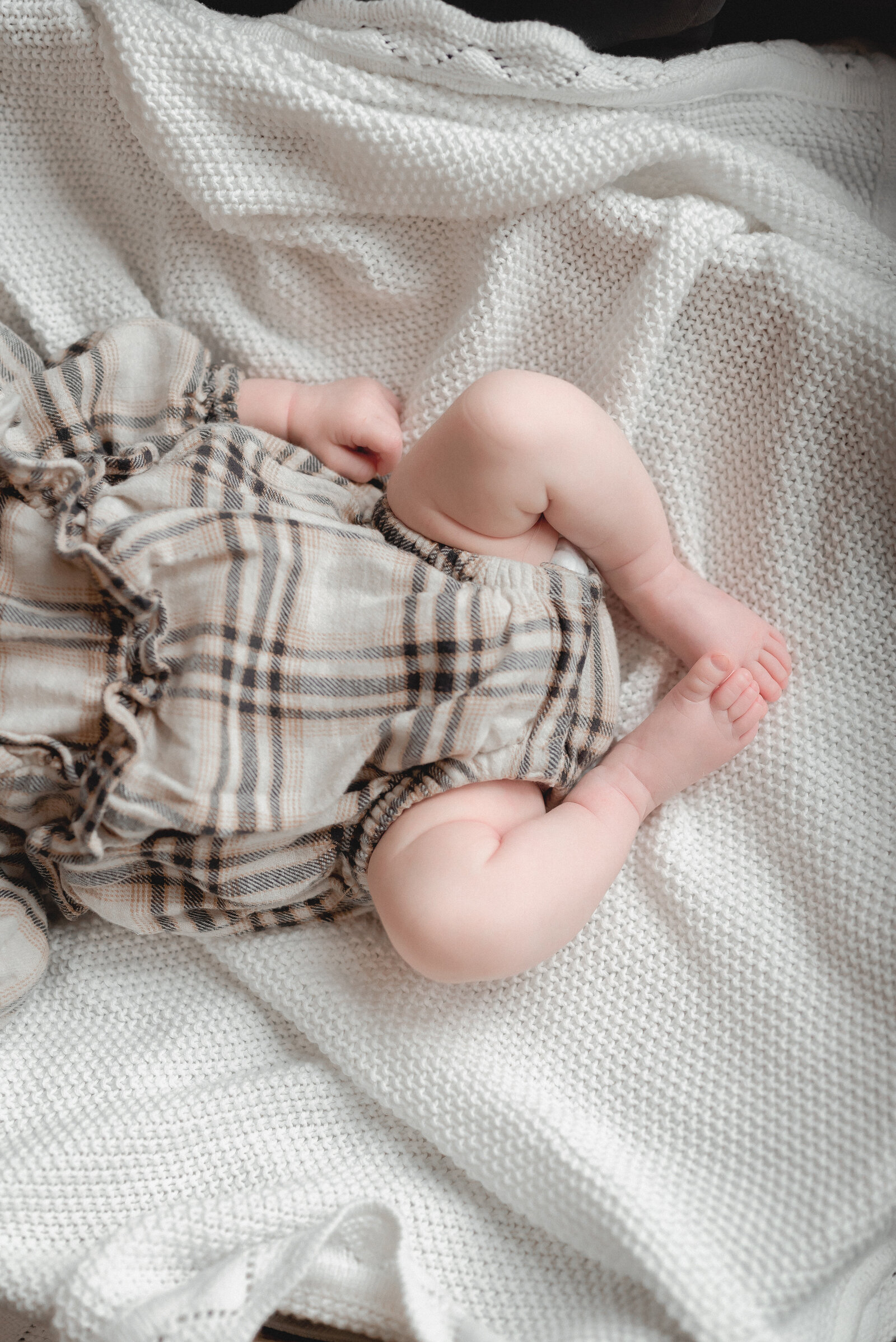 Newborn dressed in a plaid ruffle outfit in Ottawa Canada