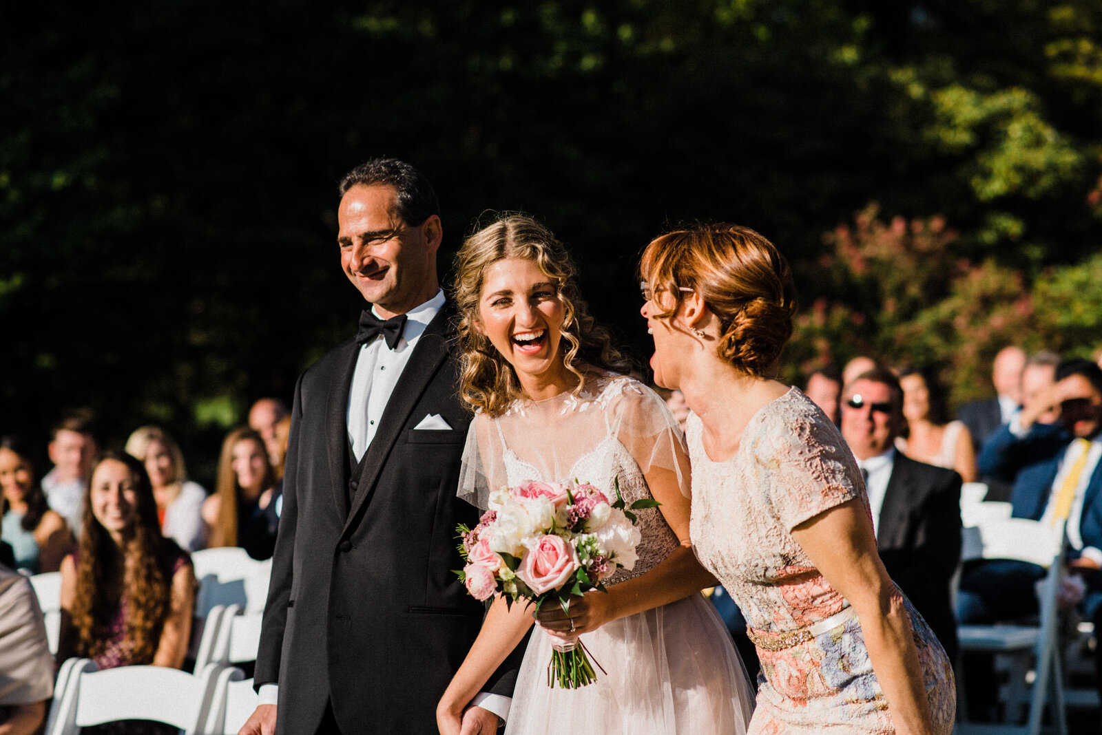 bride and mom laughing down aisle processional