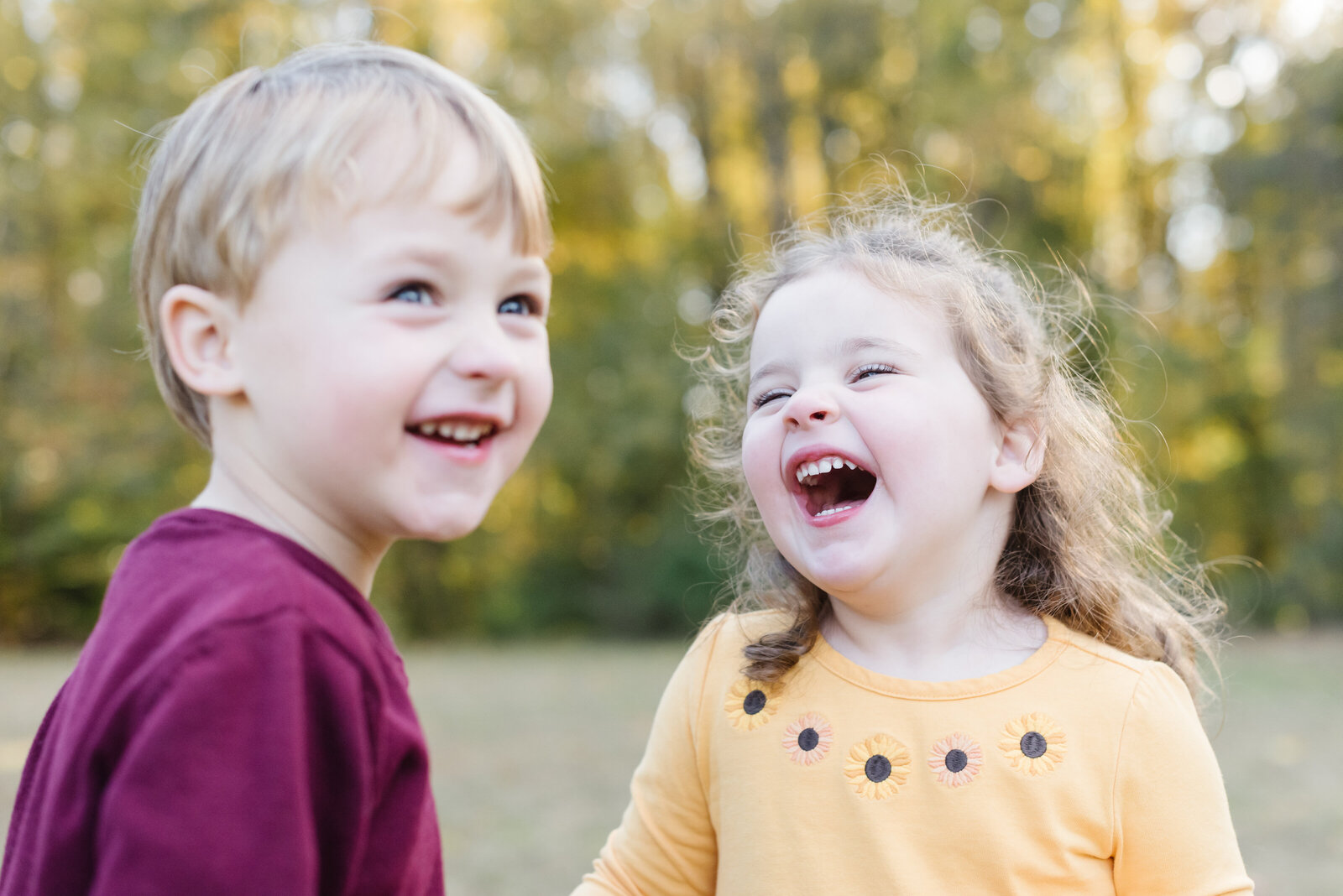 Boy in red shirt smiling with girl in yellow shirt laughing nearby - Virginia Family Photographer