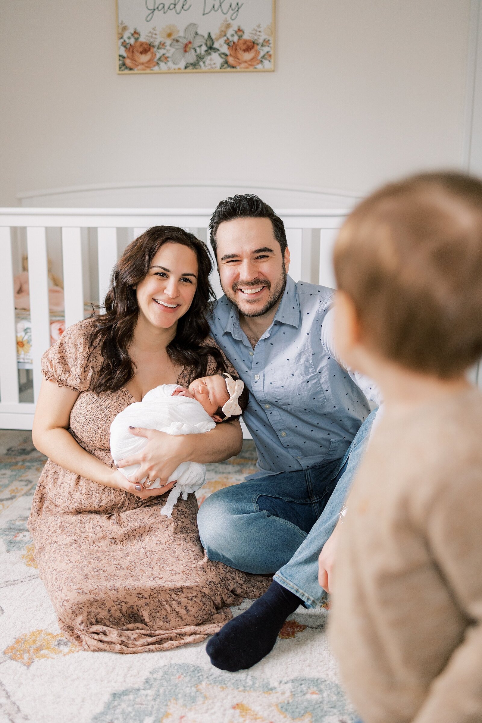 mom and dad holding new baby looking at toddler brother Newborn Photography West Chester PA