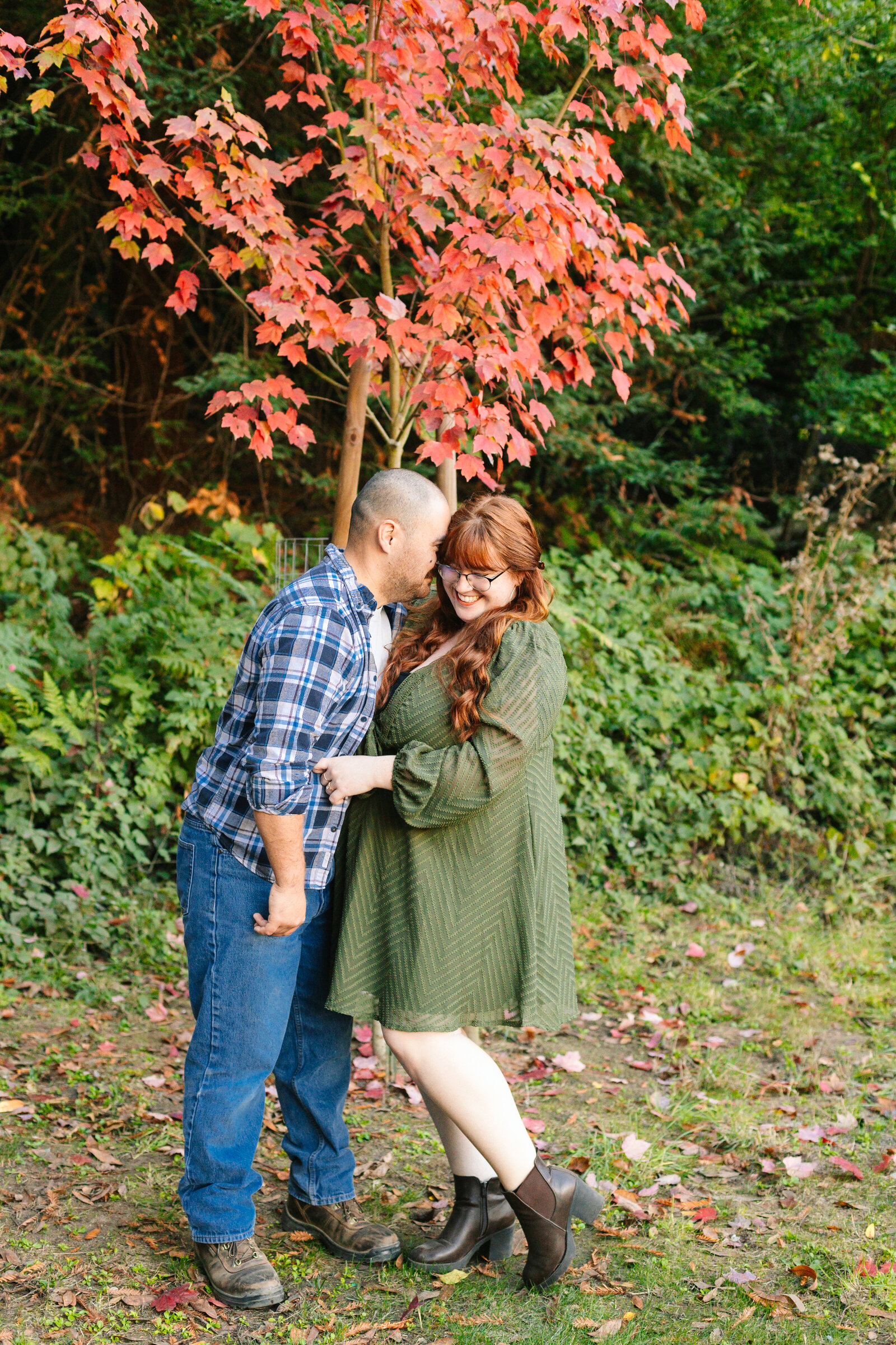A family of 3 poses for photos in a forest in Santa Cruz, Ca.