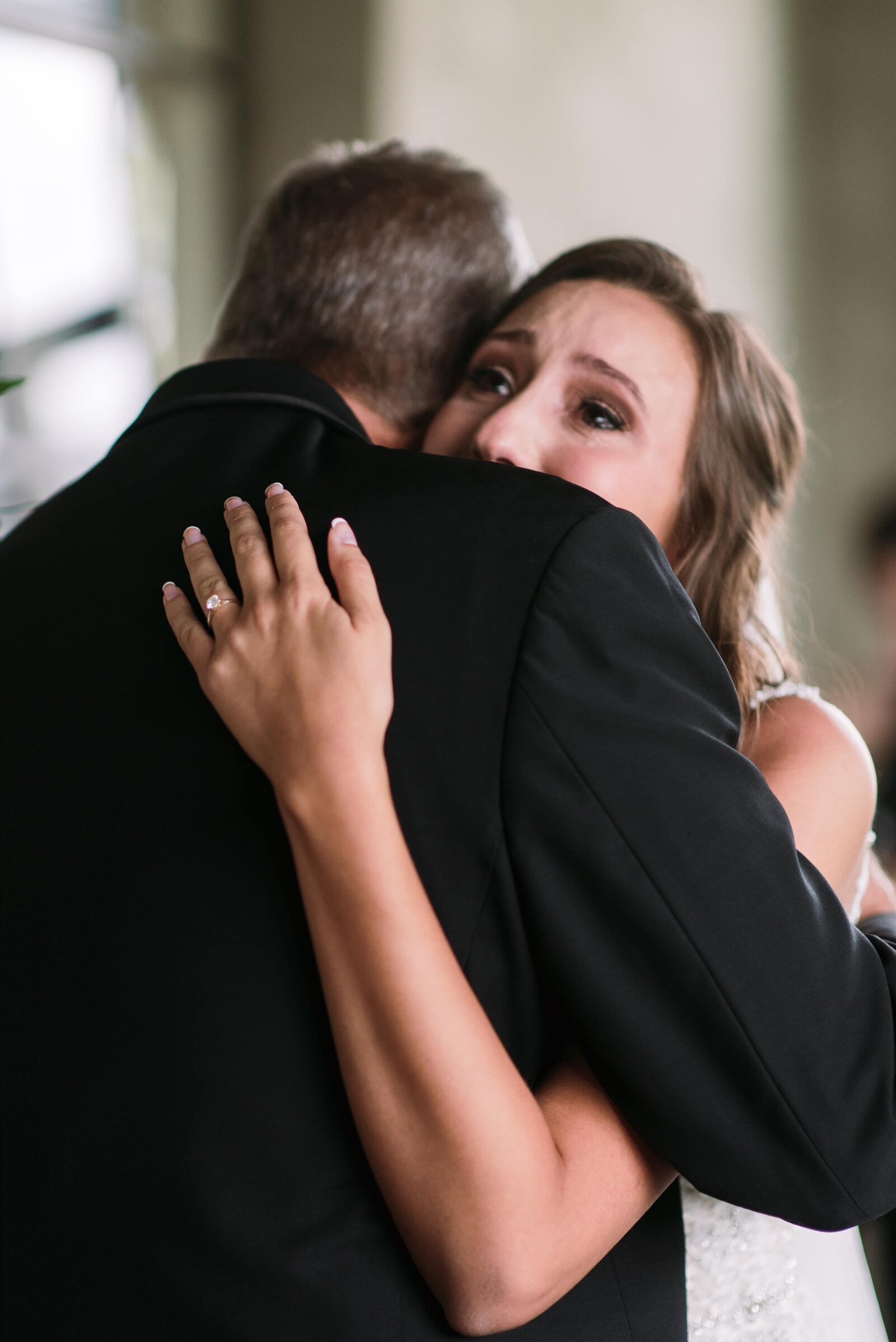A bride hugs and cries at seeing her father at her Summerour Studio Wedding.