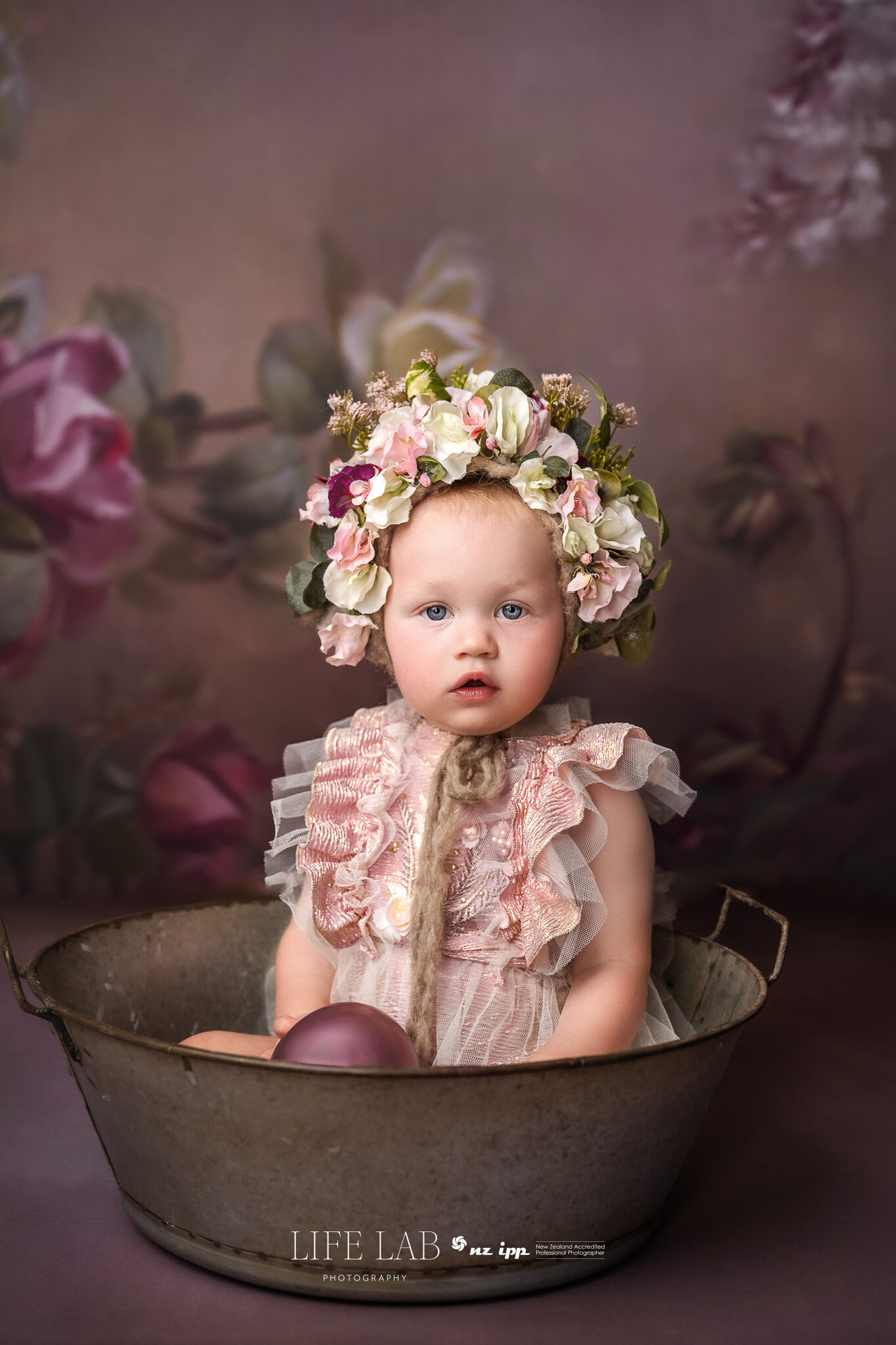 fine art portrait of 1 year old with ott flower headress and serious cute face