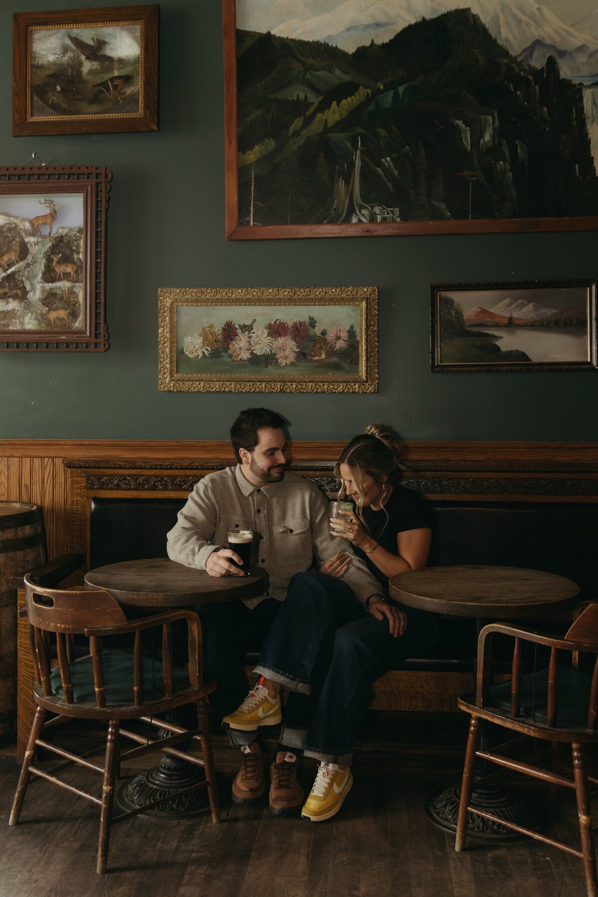 Couple sitting with wall with paintings by destination wedding photographers
