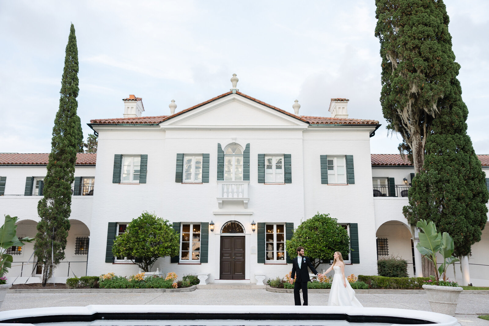 wedding couple standing in front of crane cottage in jekyll island, georgia