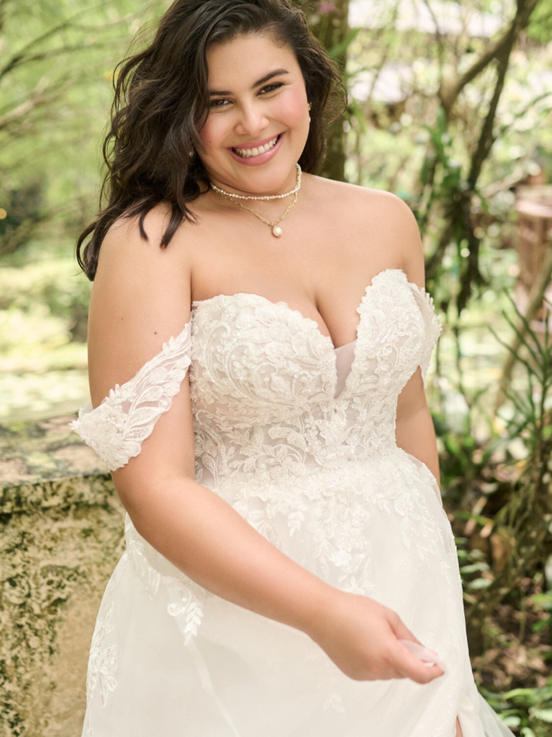Bride smiling in an off-the-shoulder lace wedding gown during an outdoor shoot