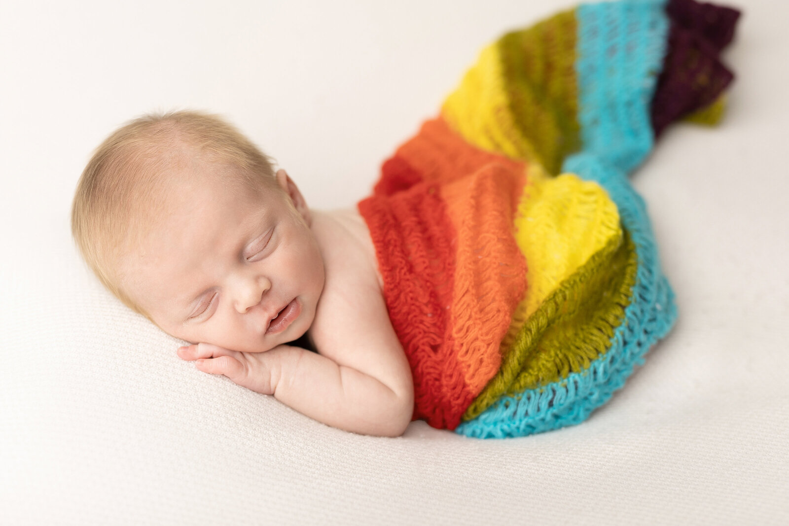 newborn baby in a rainbow wrap