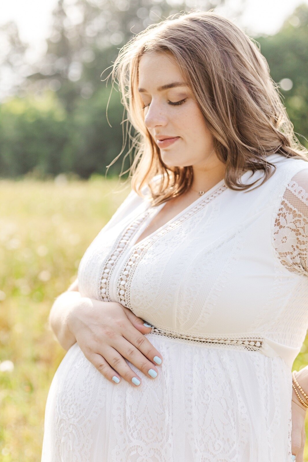 Pregnant woman looking down at her belly