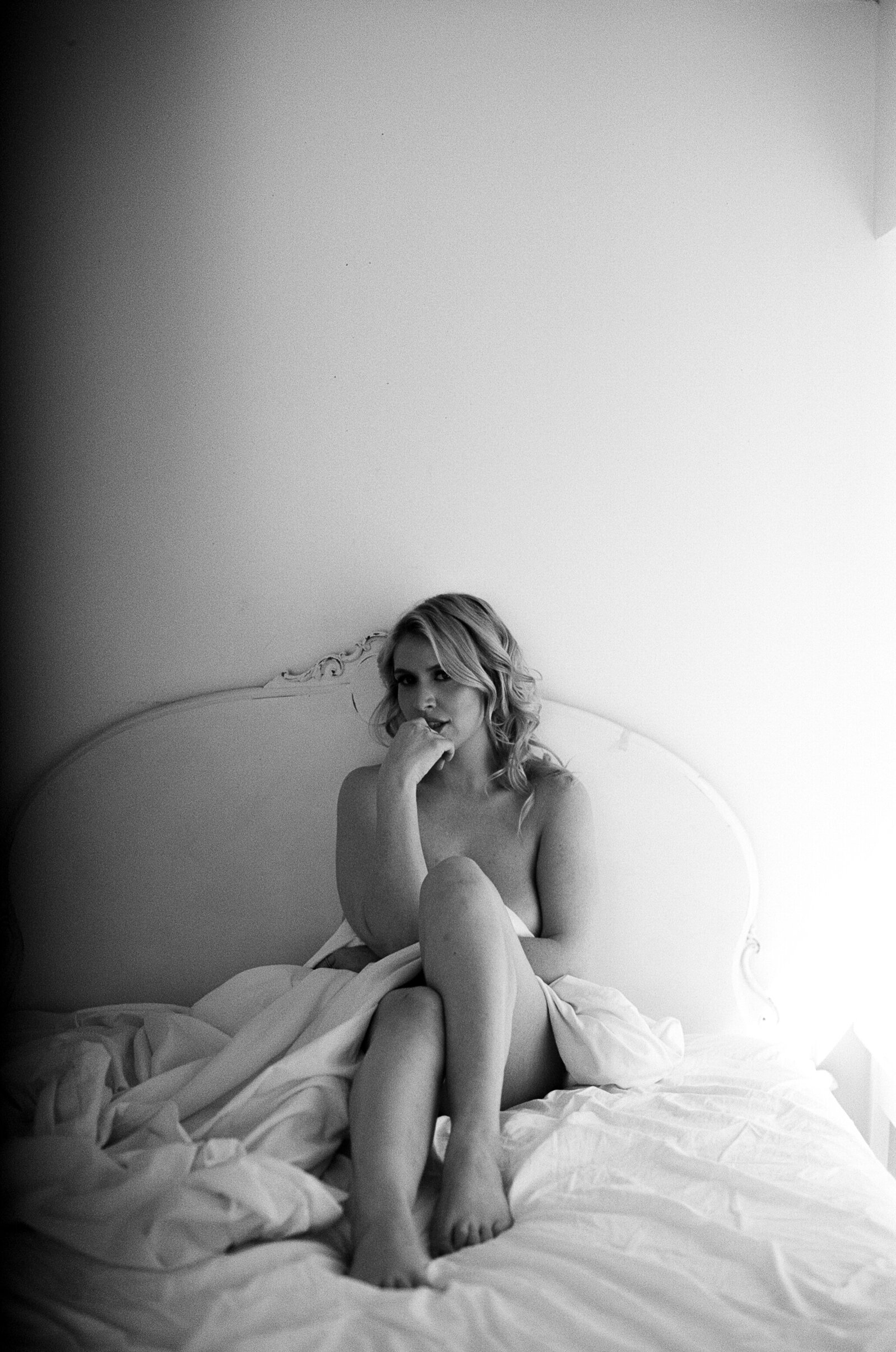 Boudoir photo of woman sitting on a bed