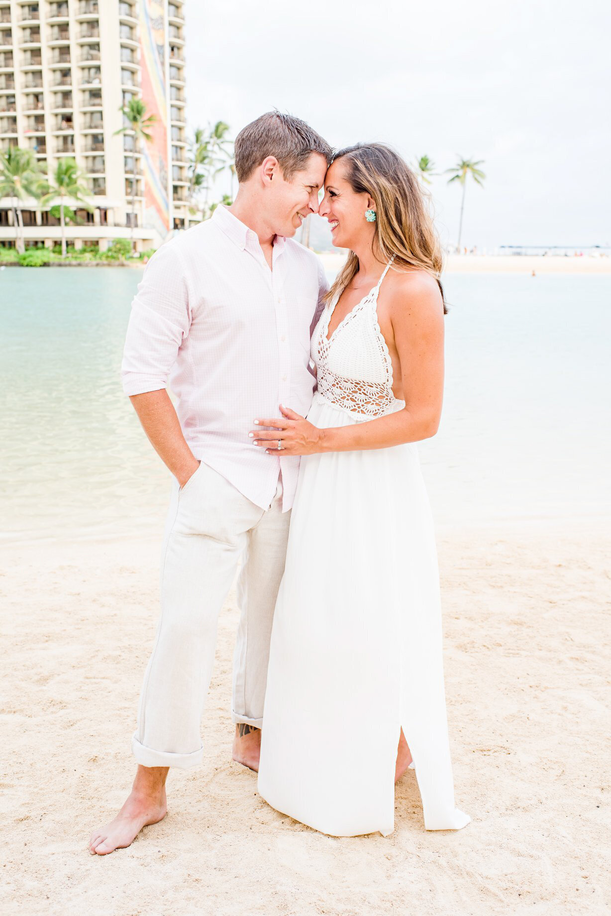Hilton Hawaiian Village Wedding Photography, couple standing on the beach with their arms around each other