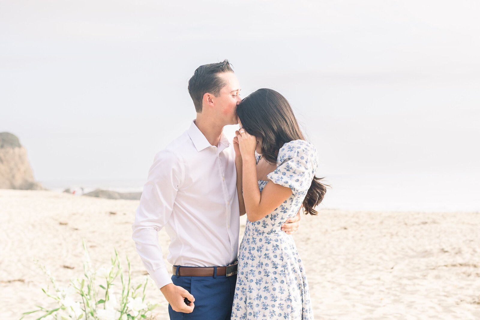 candid couples photos with man holding a woman and kissing her forehead as she cries happy tears captured by wedding photographer bay area