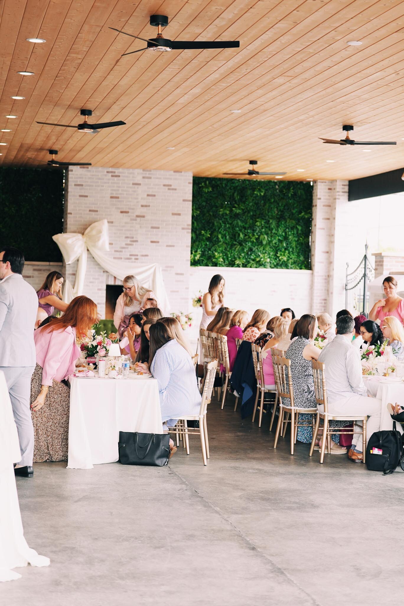 Guests in pastel and floral outfits gather around at grbic events, a luxury indoor wedding venue in st. louis