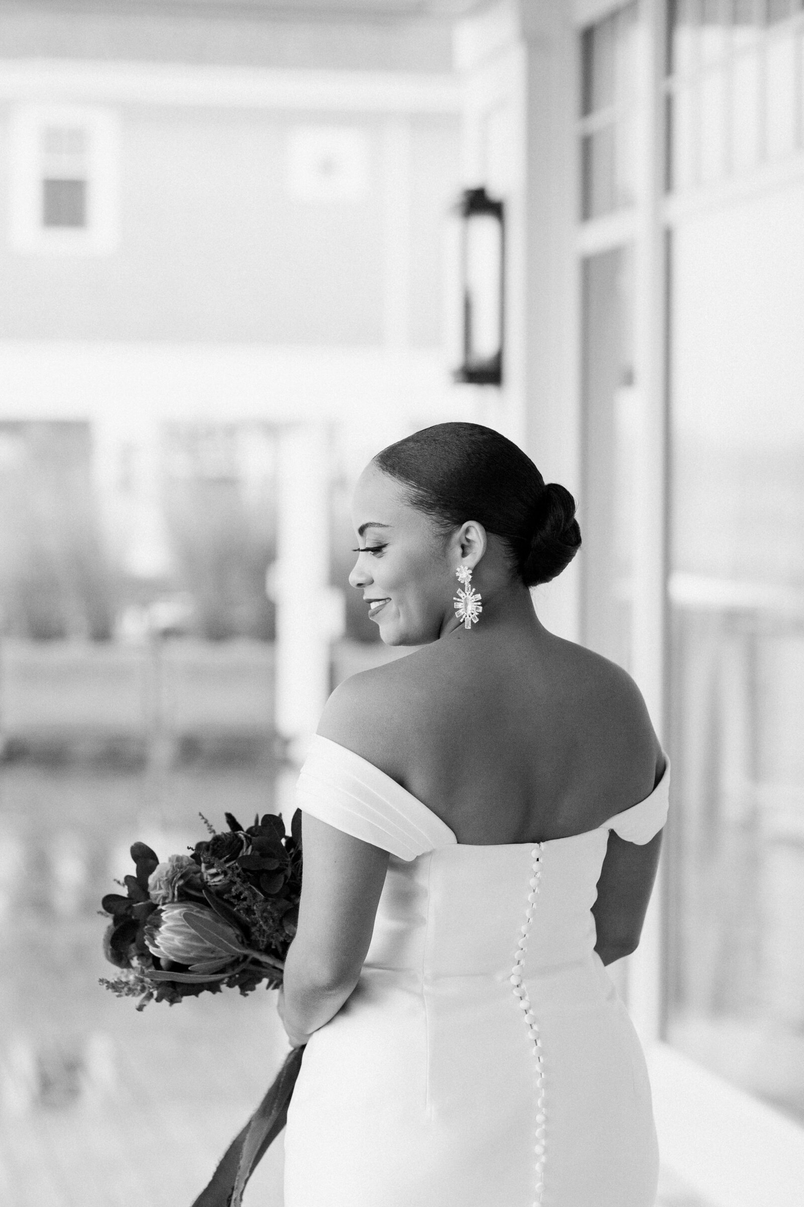 Black and white photo of a bride as she looks over her shoulder
