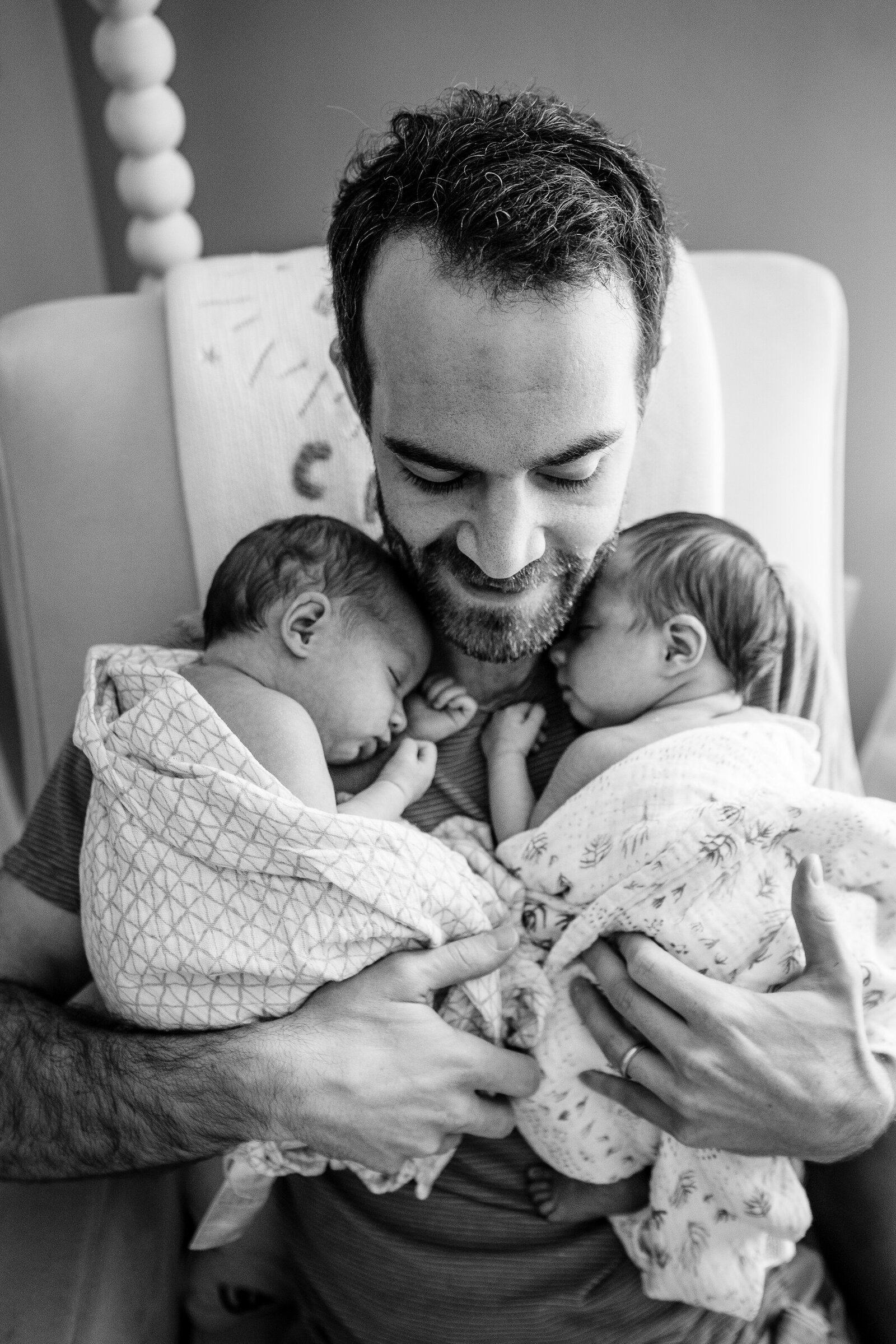 dad holds twin girls to chest