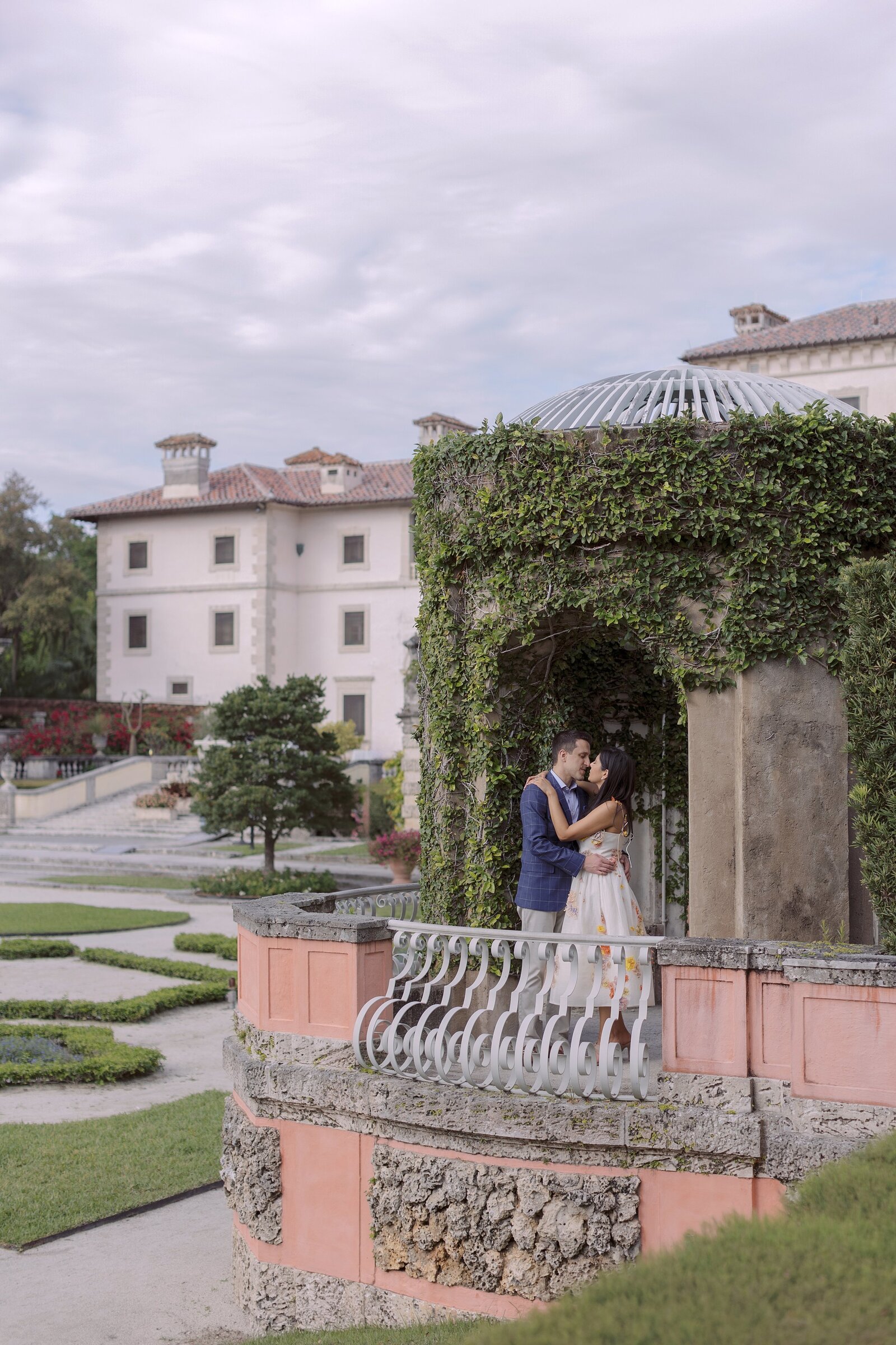 Couple kiss in pergola at Vizcaya Museum Miami.