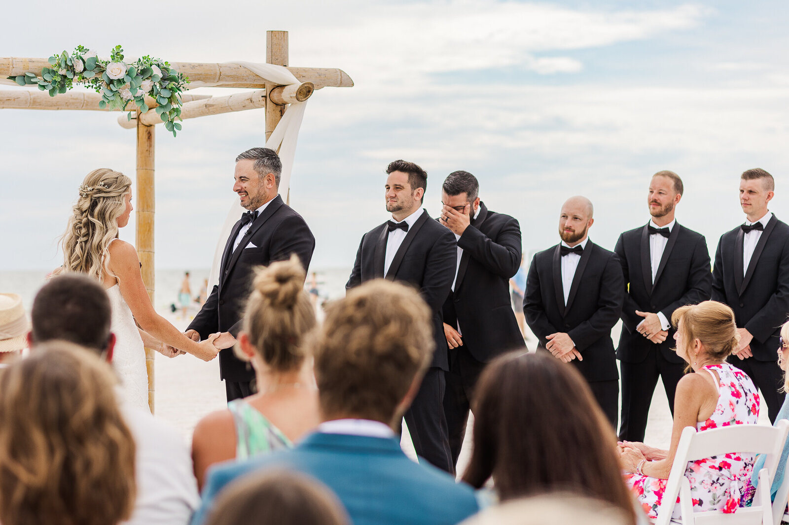 A groomsmen cries of happiness during a wedding ceremony on the beach