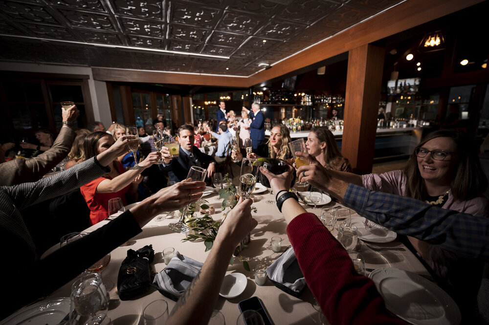 table of people raising their glasses for a toast