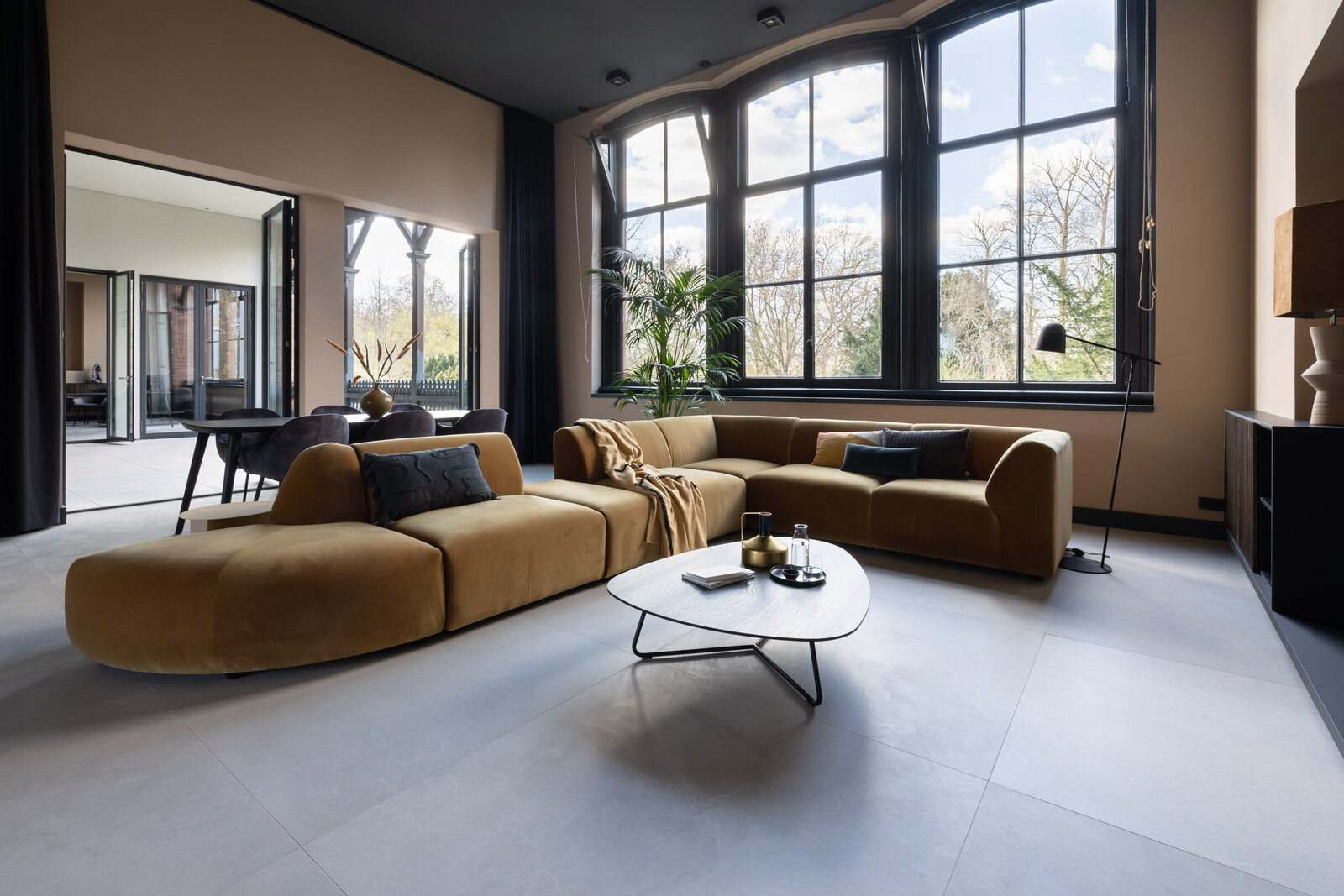 Grote woonkamer met grote bank in warme kleuren in en gemeubileerd appartement in Groningen. Stijlvol ingericht en luxe uitstraling.