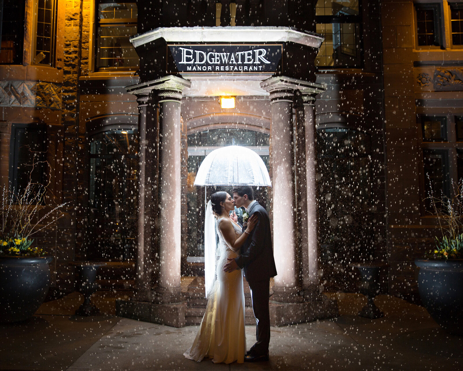wedding couple in the rain with umbrella at night at Edgewater Manor in Hamilton