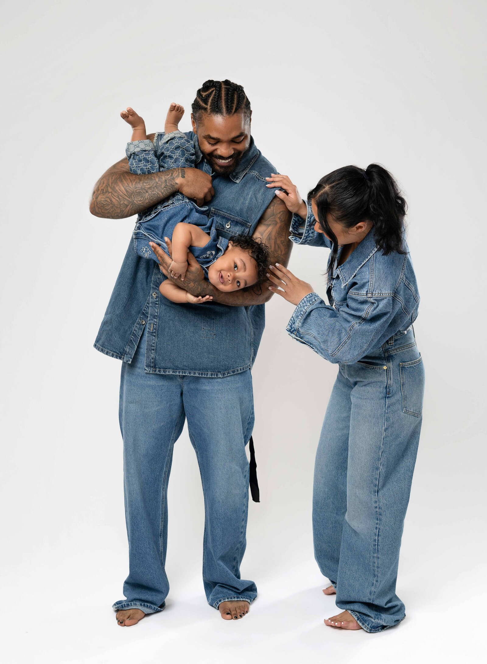 Dad holding baby upside down and Mom smiling at them.