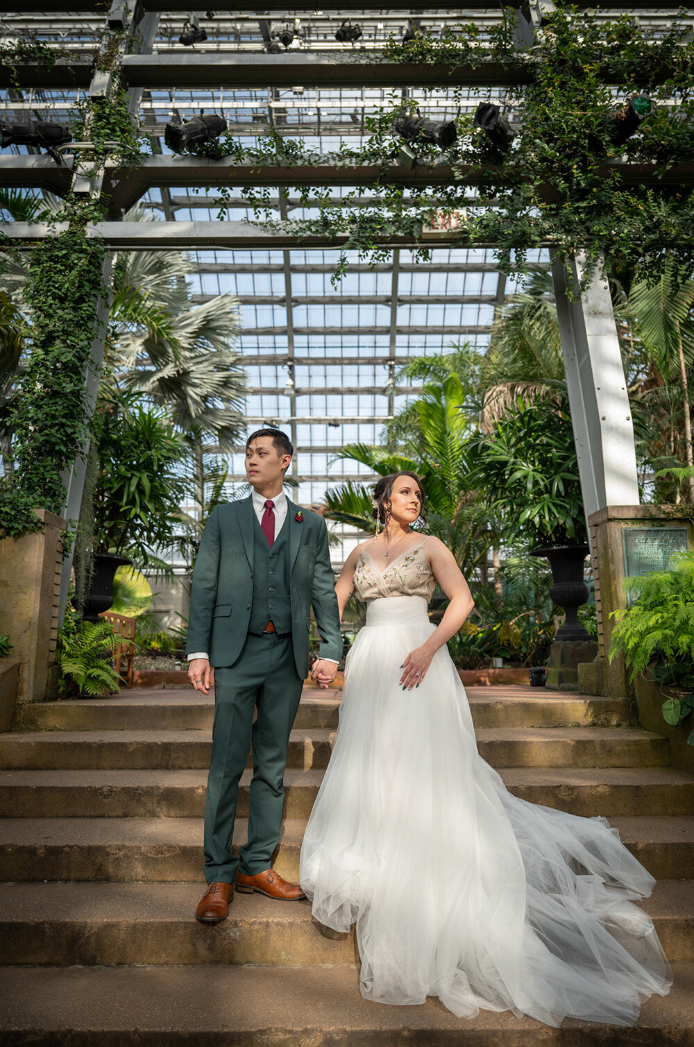 bride and groom on stairway in greenhouse
