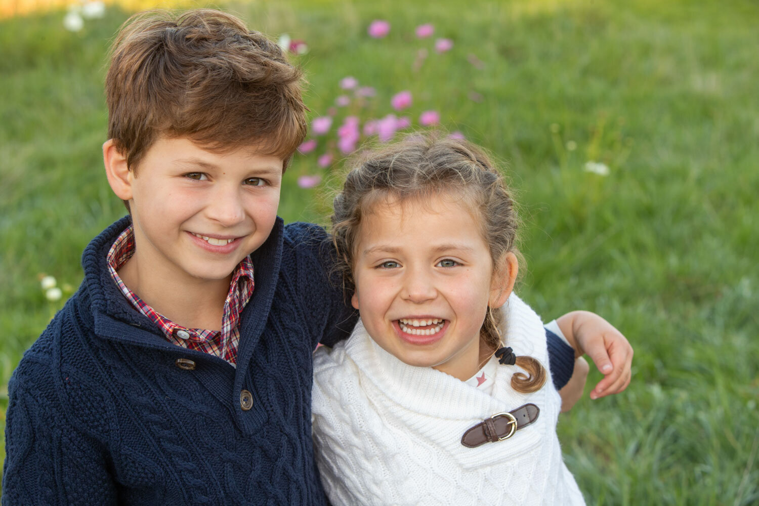 A boy and a girl are posing for a picture and smiling