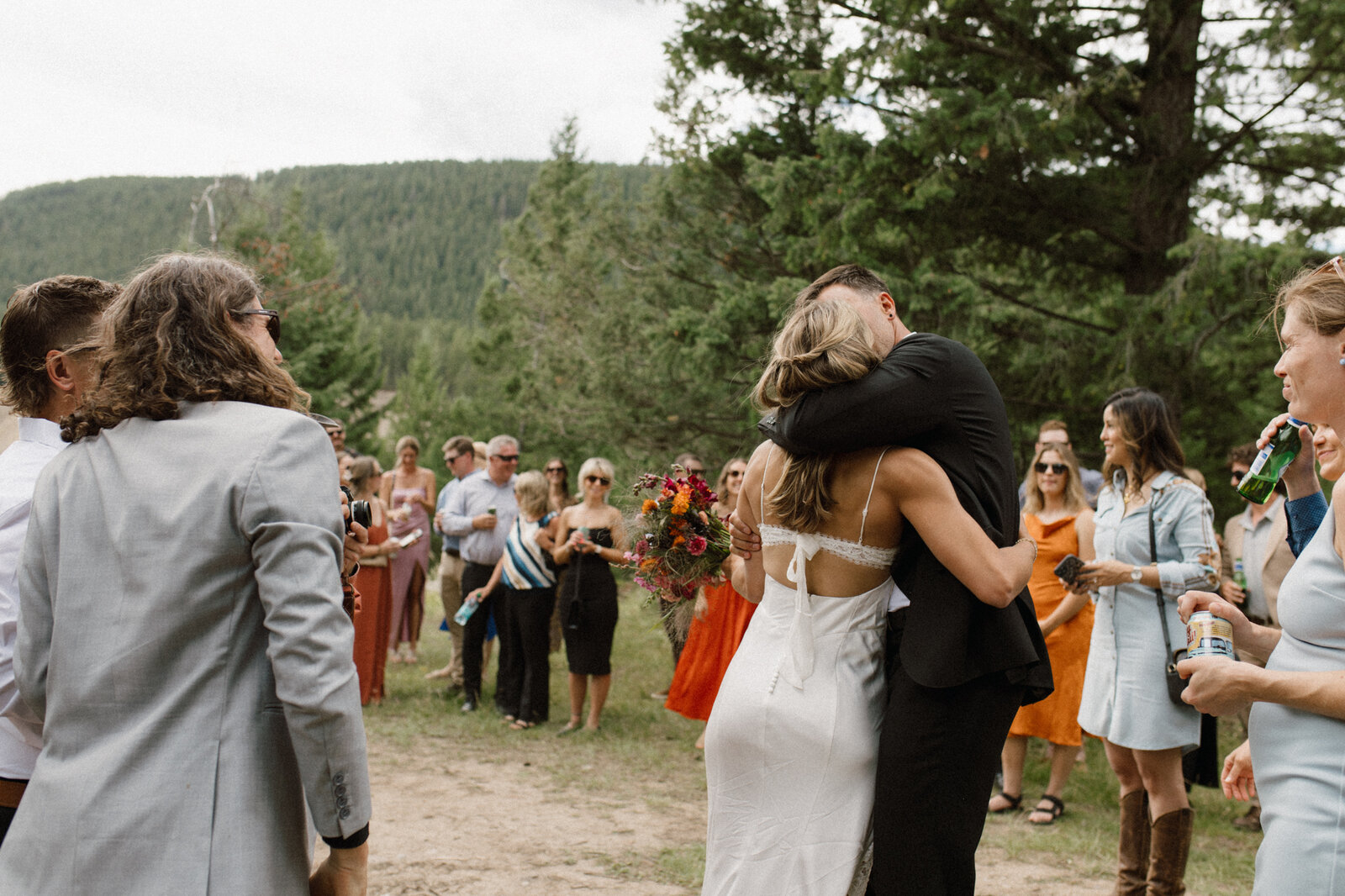 Photographer captures alberta wedding couple kiss in front of guests at their alberta wedding