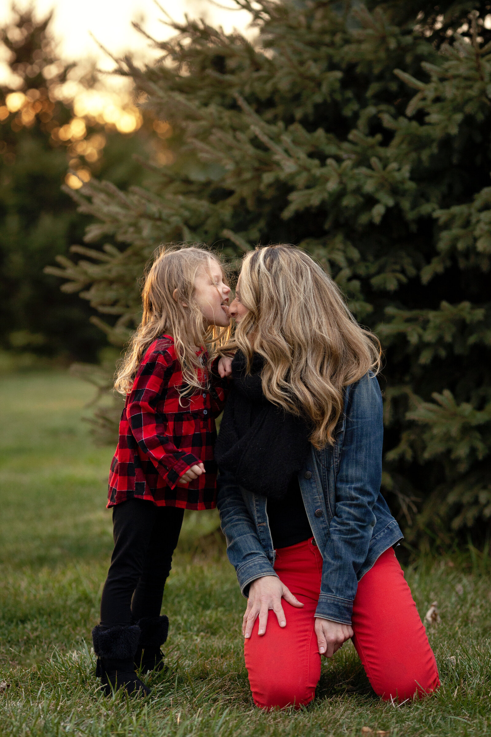 Girl licking her mom's nose, silly.