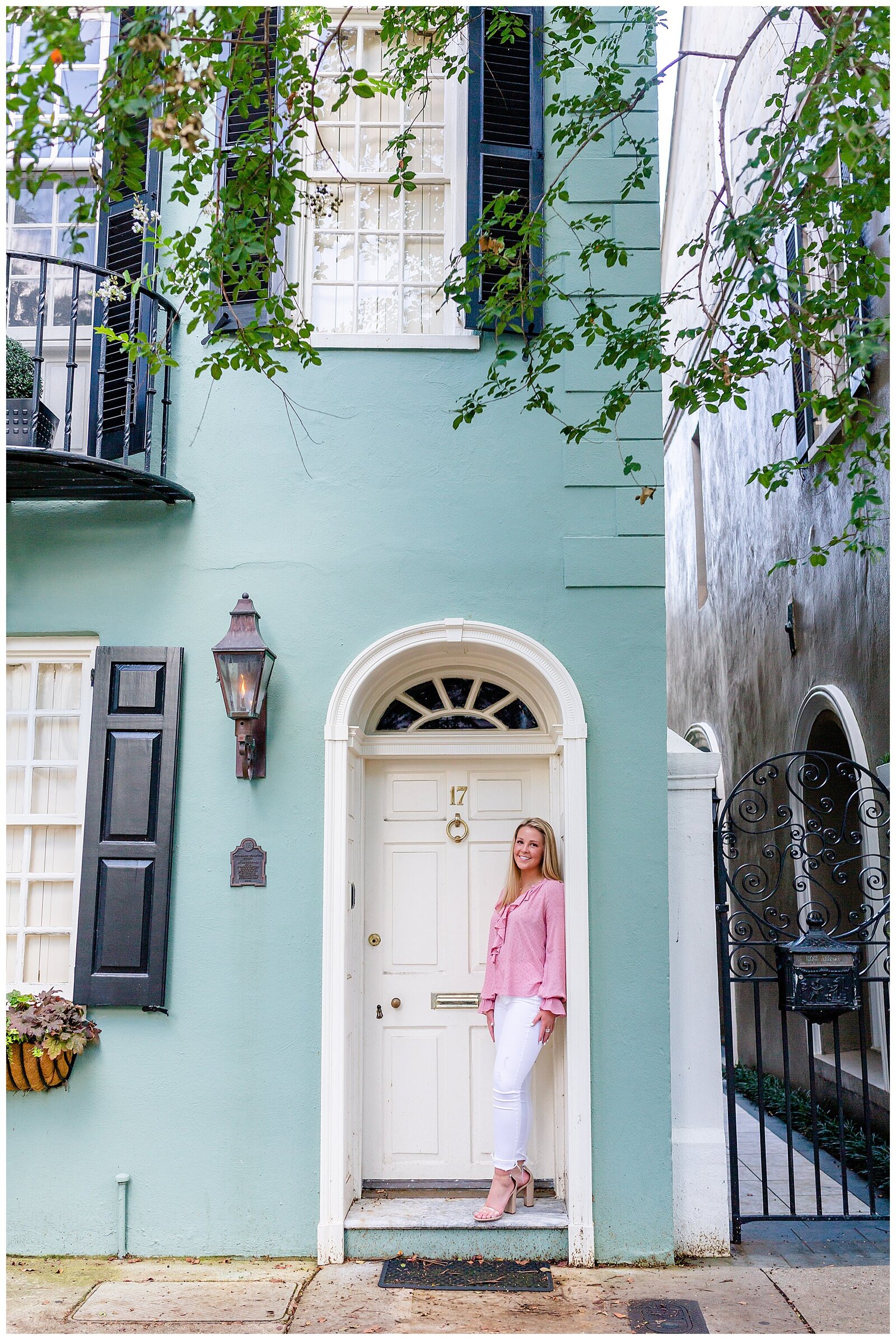 high school senior standing in door frame of blue house in Charleston Charleston, SC