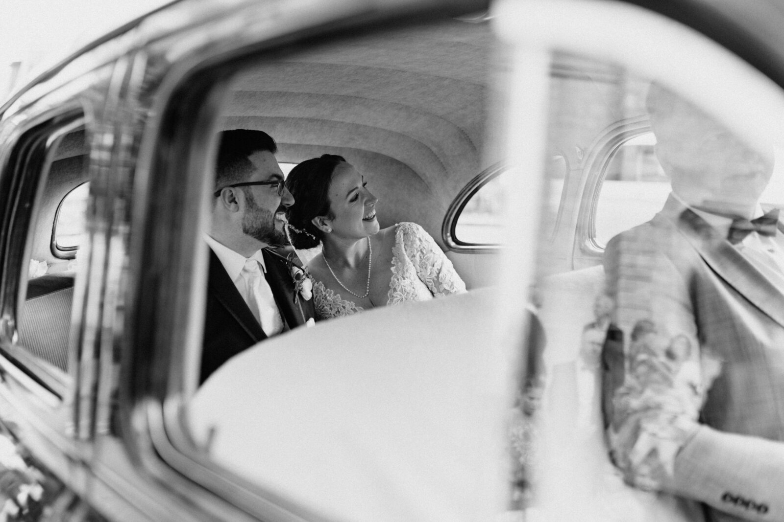 A view of the bride and groom outside the wedding car's window after the wedding