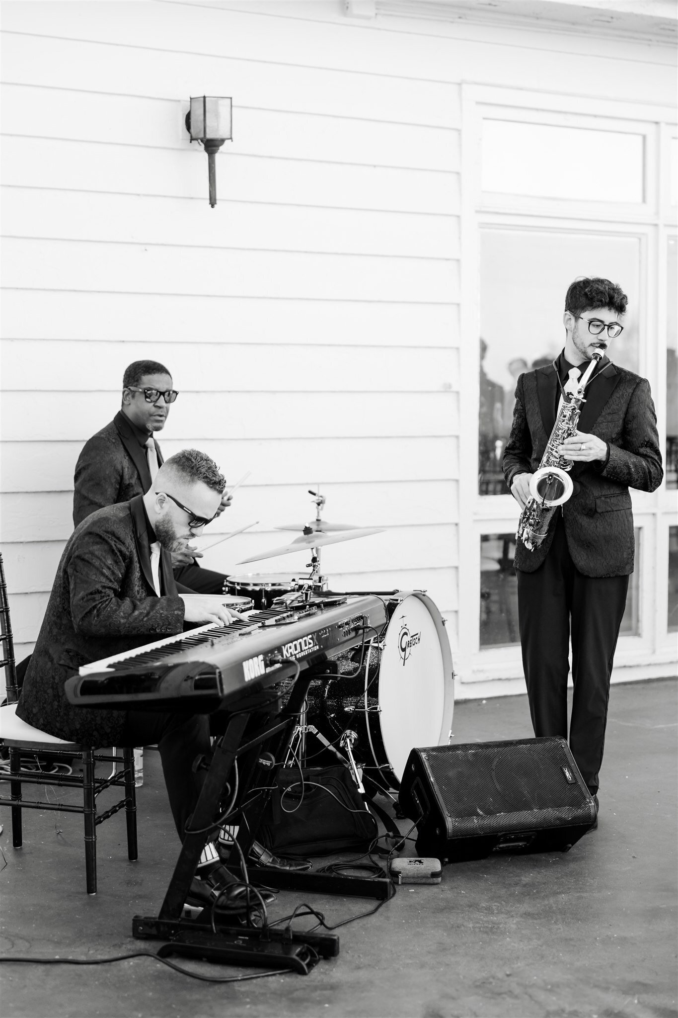 A band playing instruments at cocktail hour during a wedding reception on the porch of the Mission Point Resort on Mackinac Island