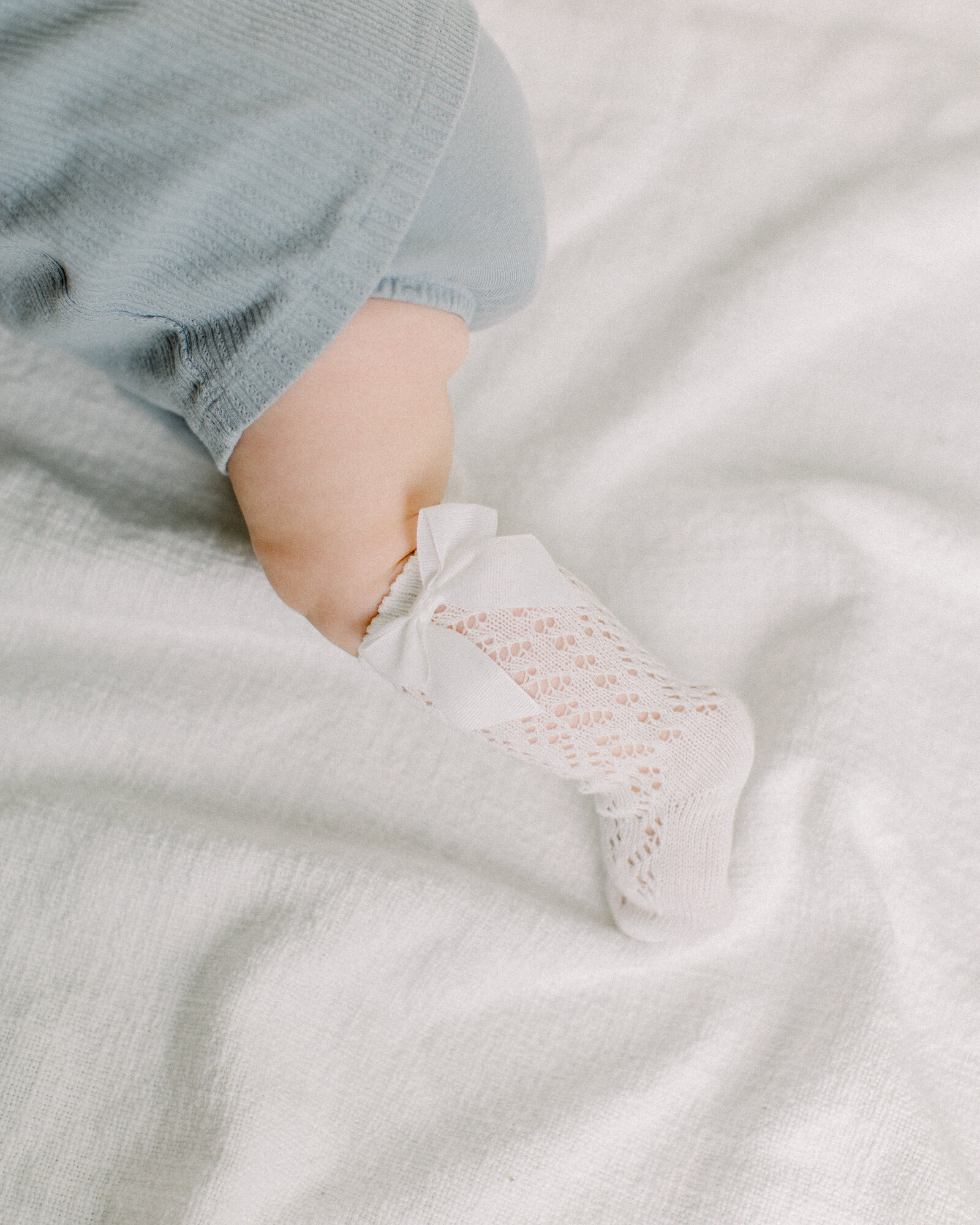 Baby in crochet stockings crawling away by NH newborn photographer Fieldstone Studio.