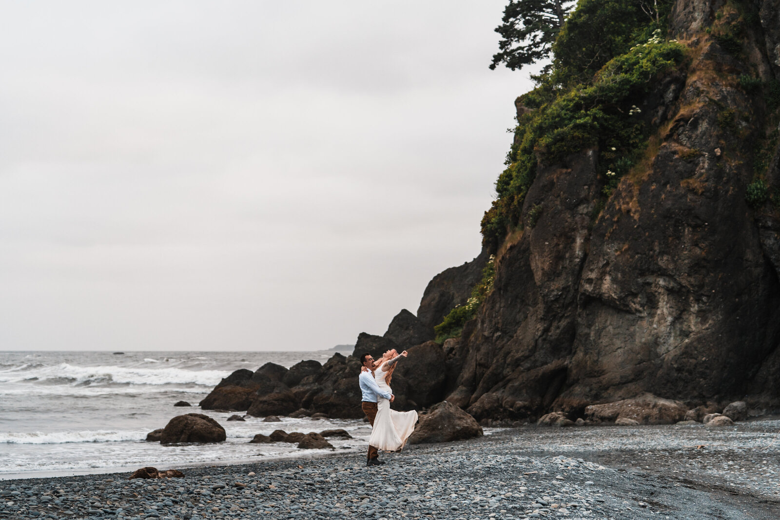 couple spinning around on ruby beach in wedding dress