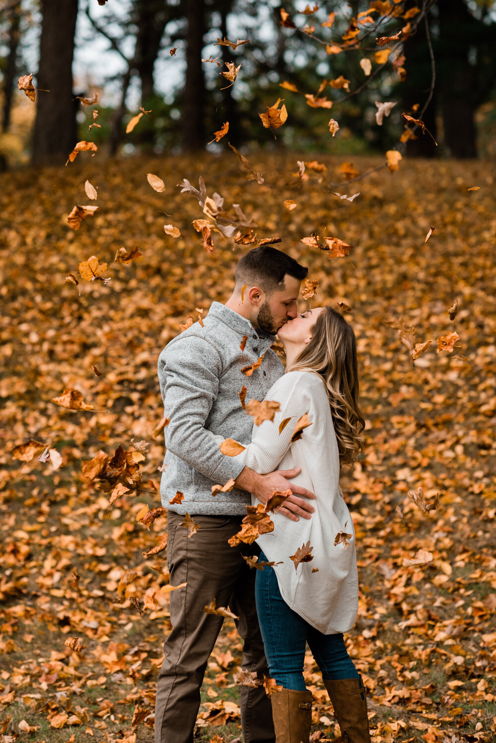 couple kiss as leaves fall