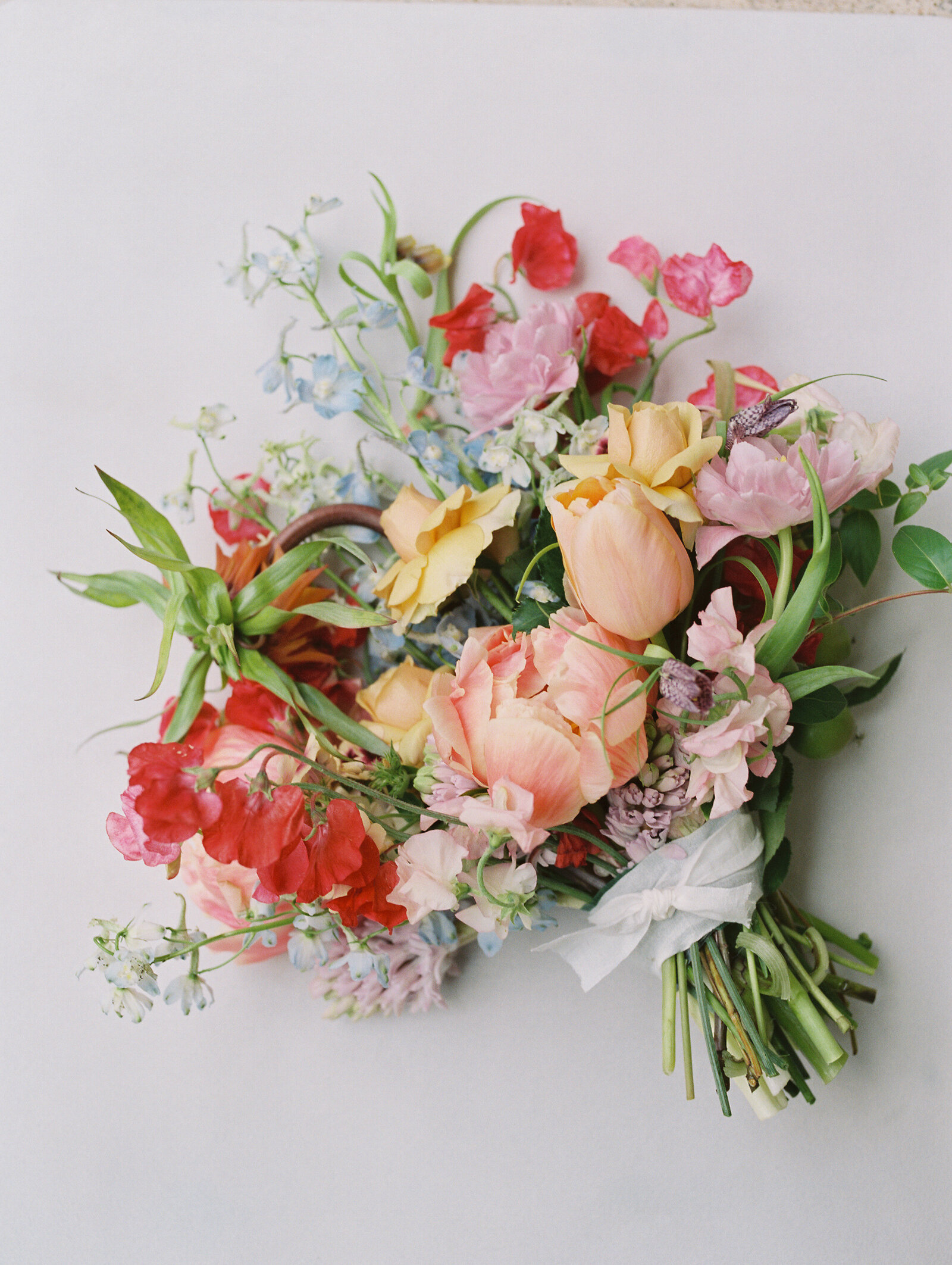 Very colorful and whimsical bouquet arrangement on a soft surface at Merrick Hollow