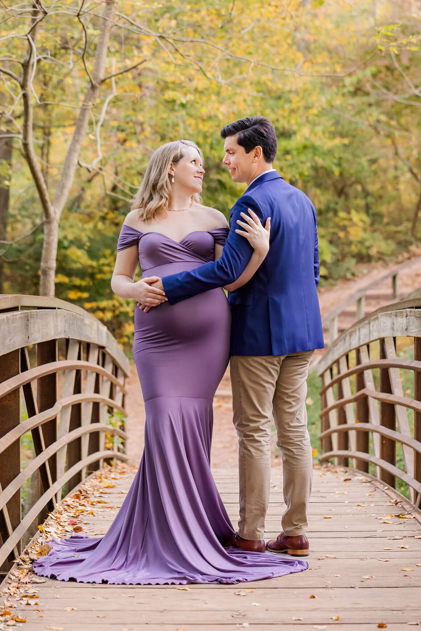 A couple posing on a bridge during their maternity portraits.
