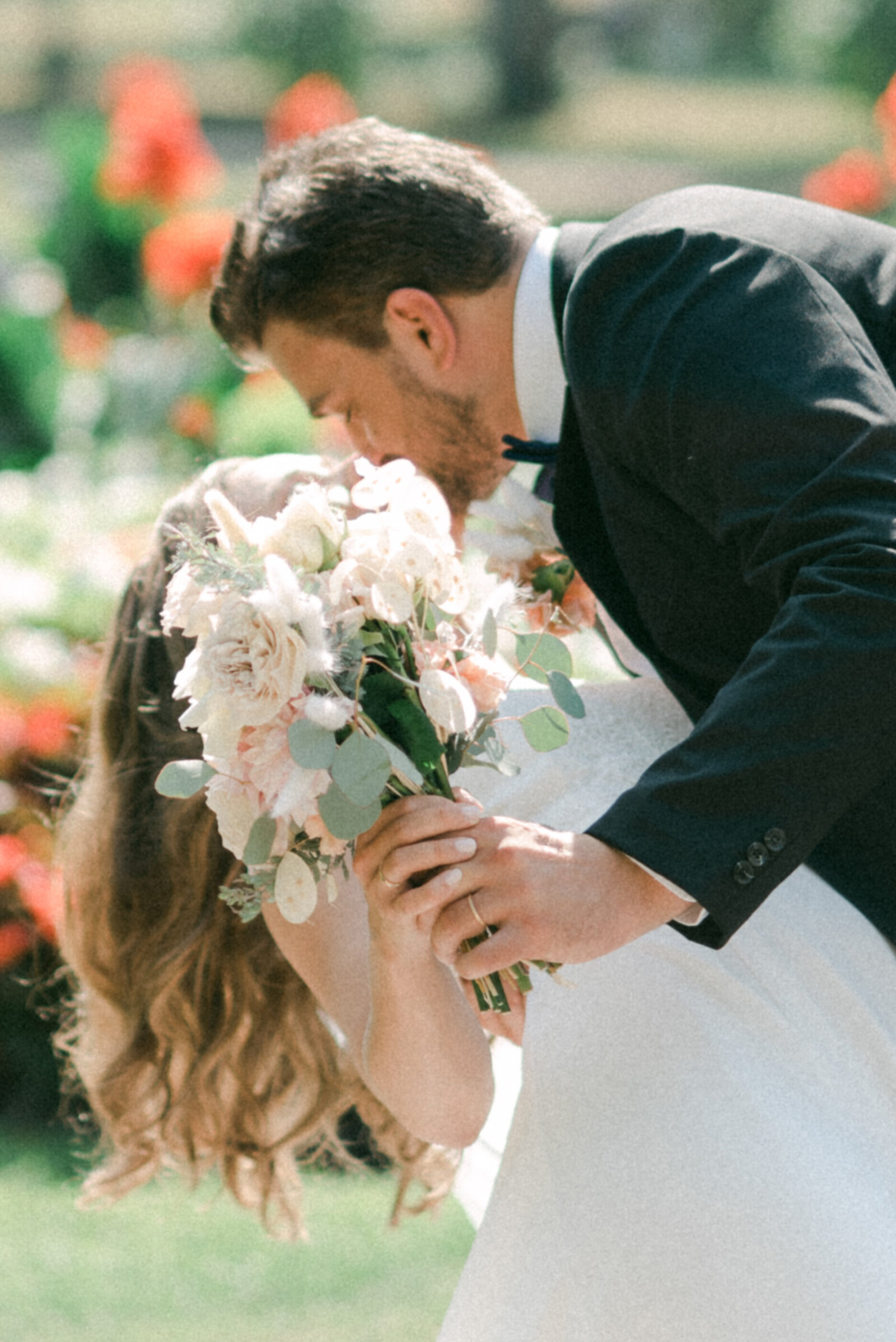 A wedding couple kissing behind a bouquet in a photograph captured by wedding photographer Hannika Gabrielsson.