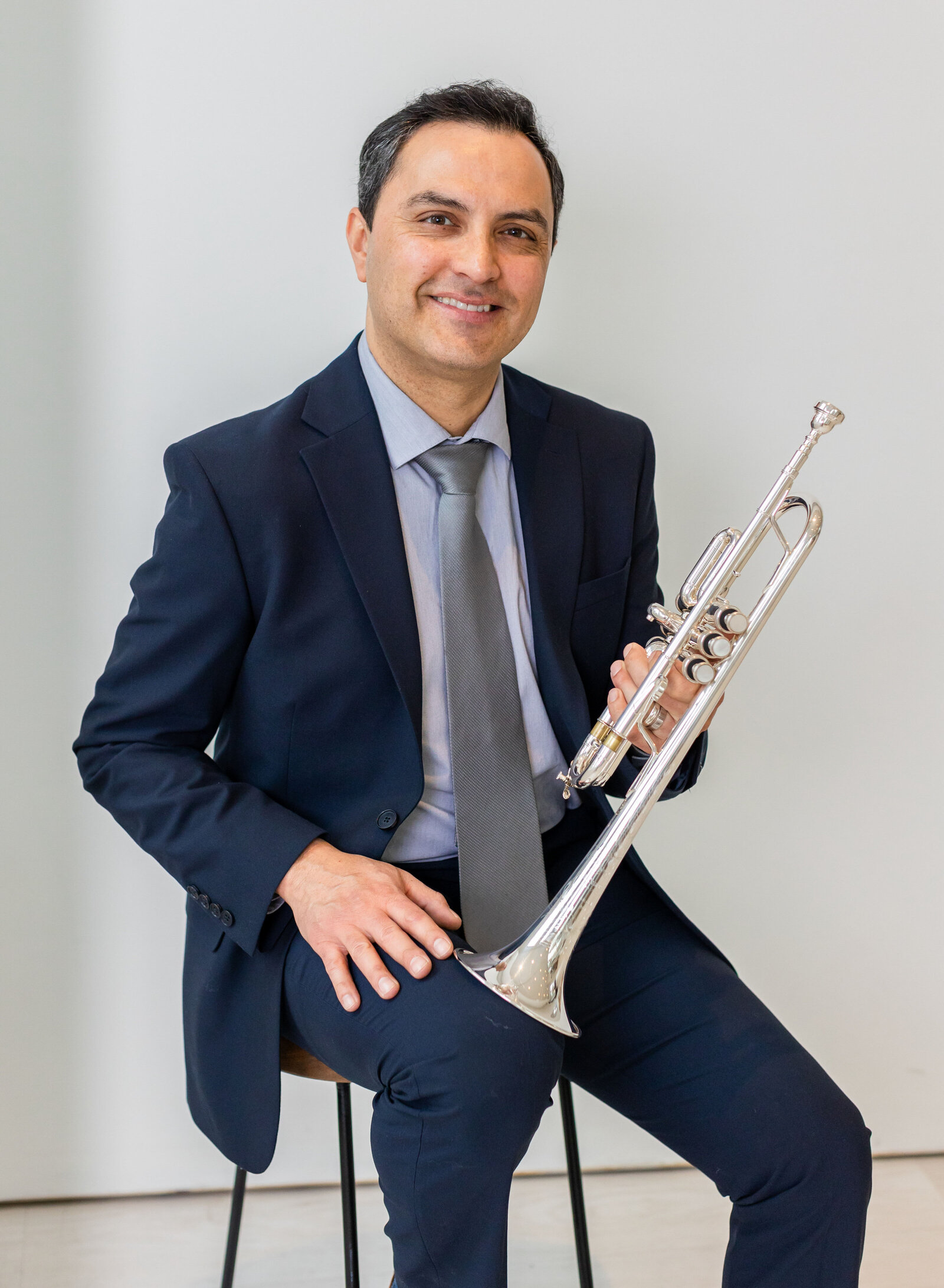 man seated with trumpet