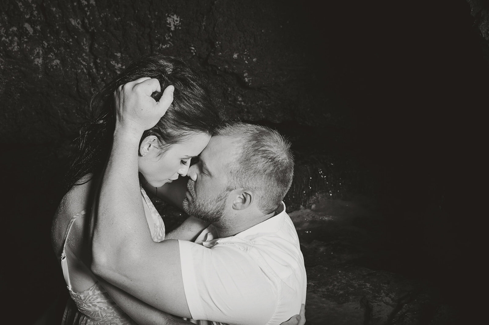 A bride and groom share a romantic moment in the water under the night sky, captured in black and white by CMH Studios.