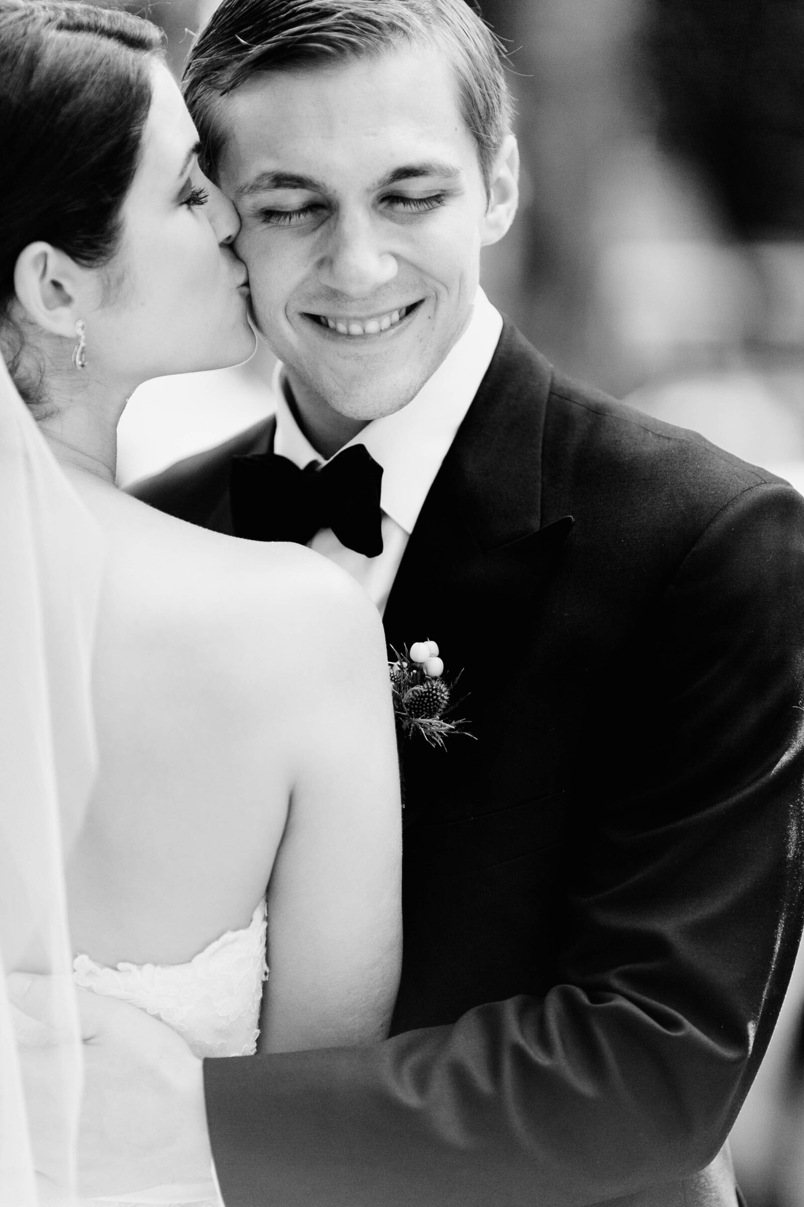 bride kissing groom on cheek