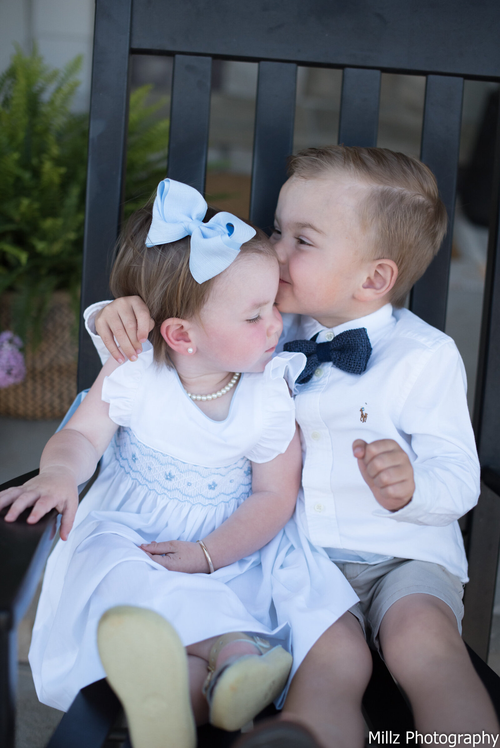 a little girl receiving a kiss on the forhead from her big brother photographed by Millz Photography in Greenville, SC