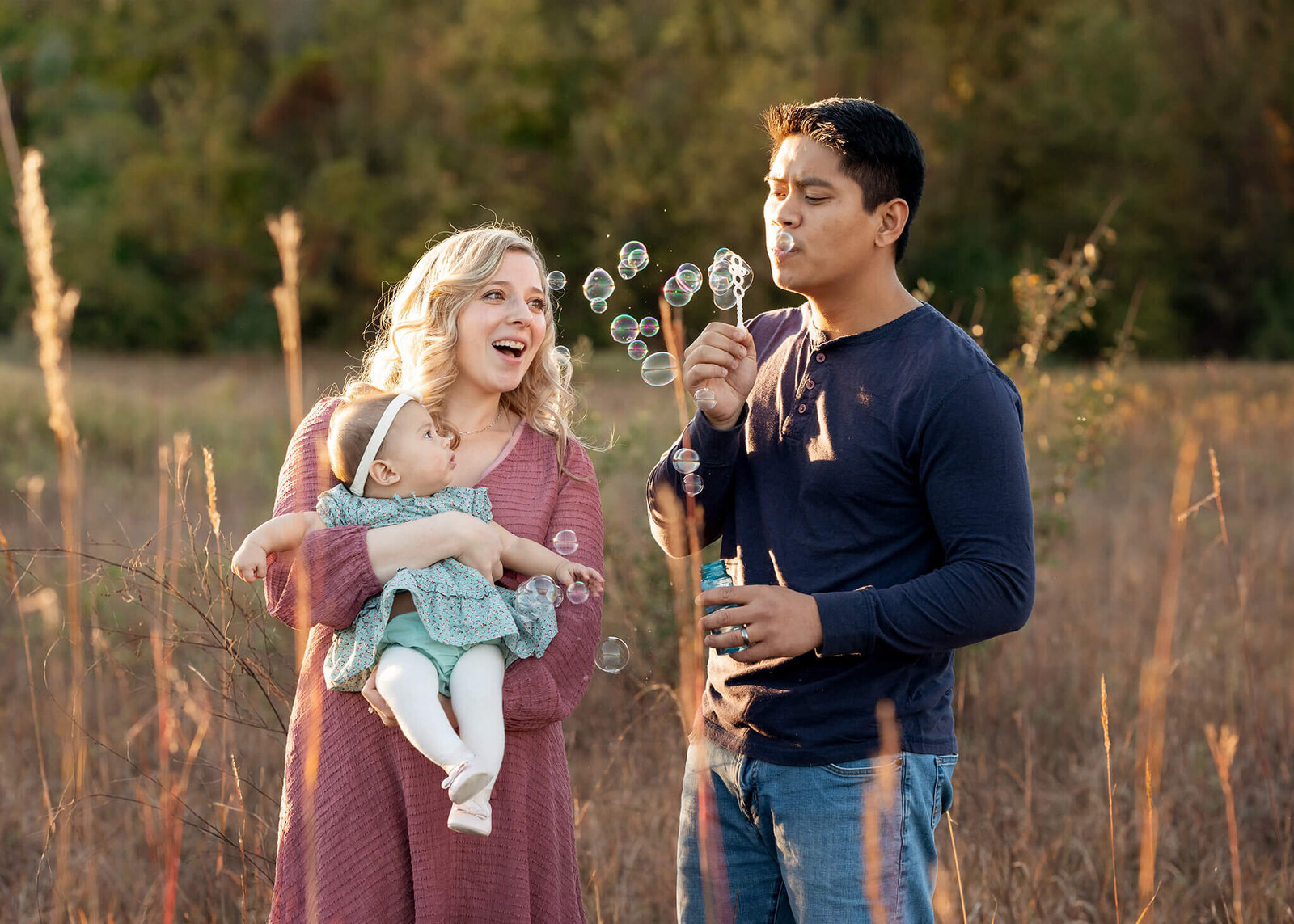 Dad blows bubbles while his baby looks on with interest